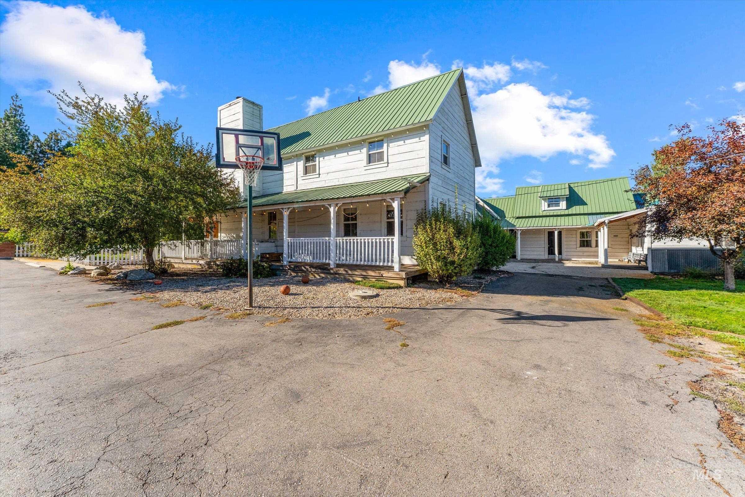 View of front of house with covered porch, a metal roof, and a chimney