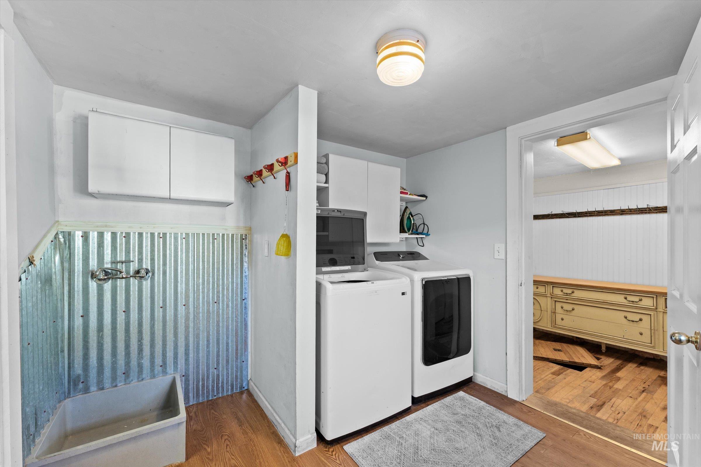 Washroom featuring light wood-type flooring and independent washer and dryer