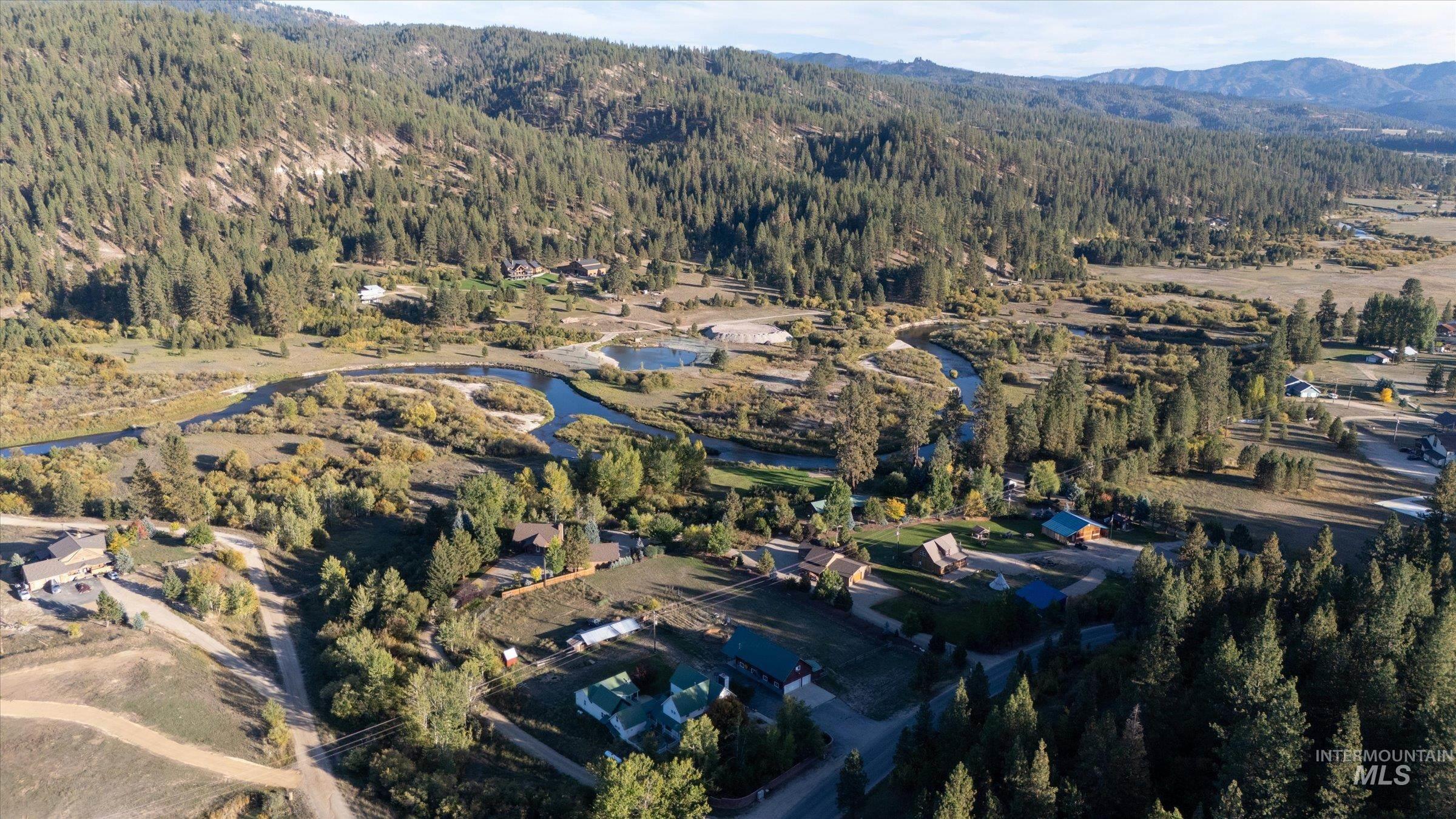 Aerial overview of property's location featuring a heavily wooded area and a water and mountain view