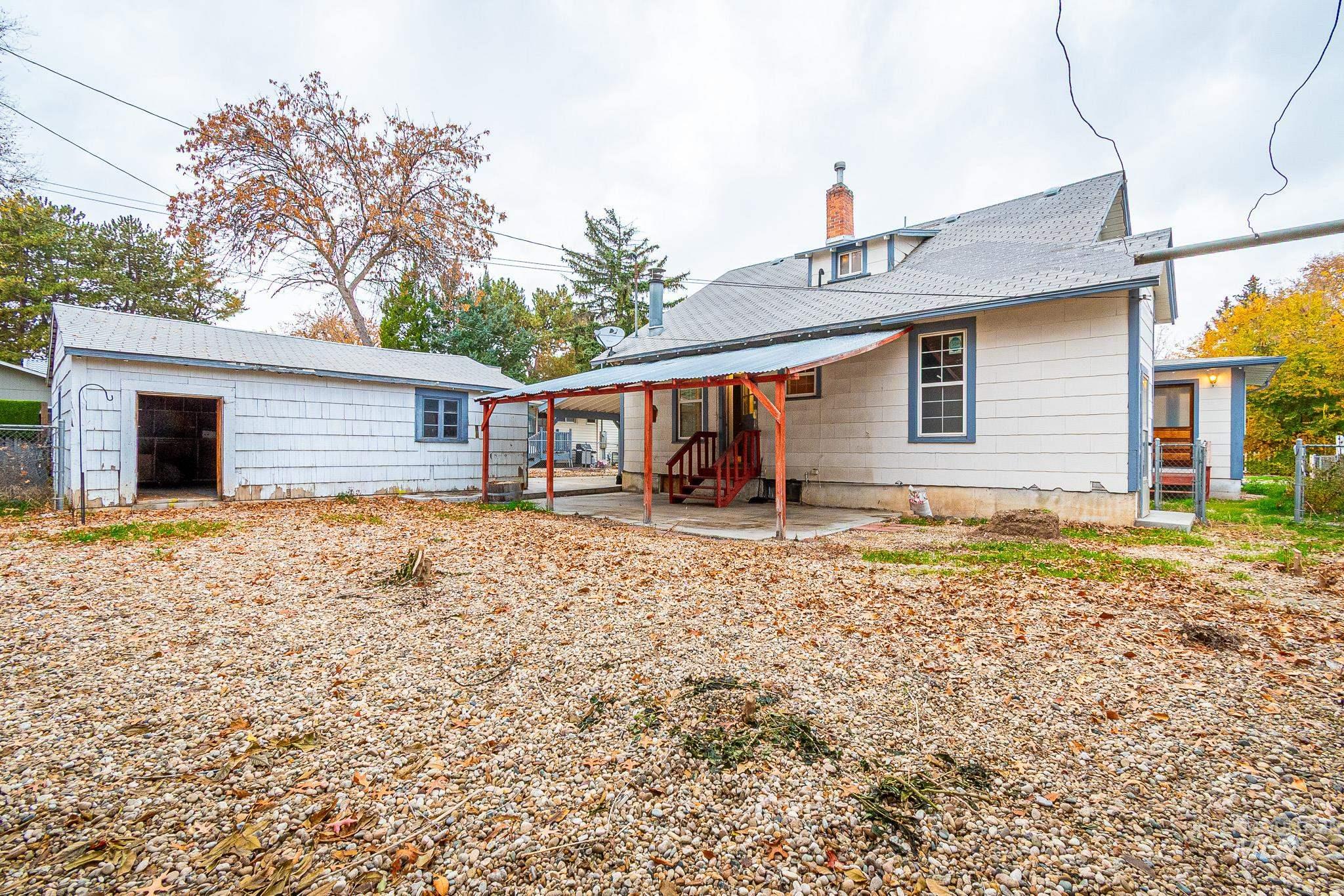 Rear view of property featuring a patio, a chimney, and an outdoor structure
