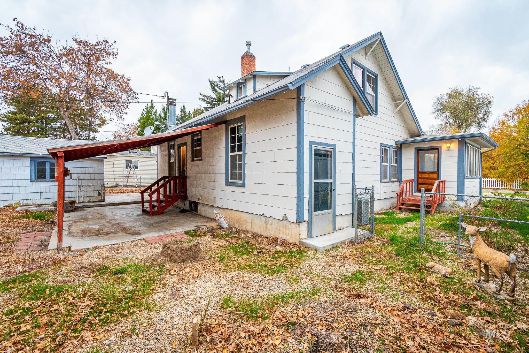 Rear view of house featuring entry steps, a chimney, and a patio area