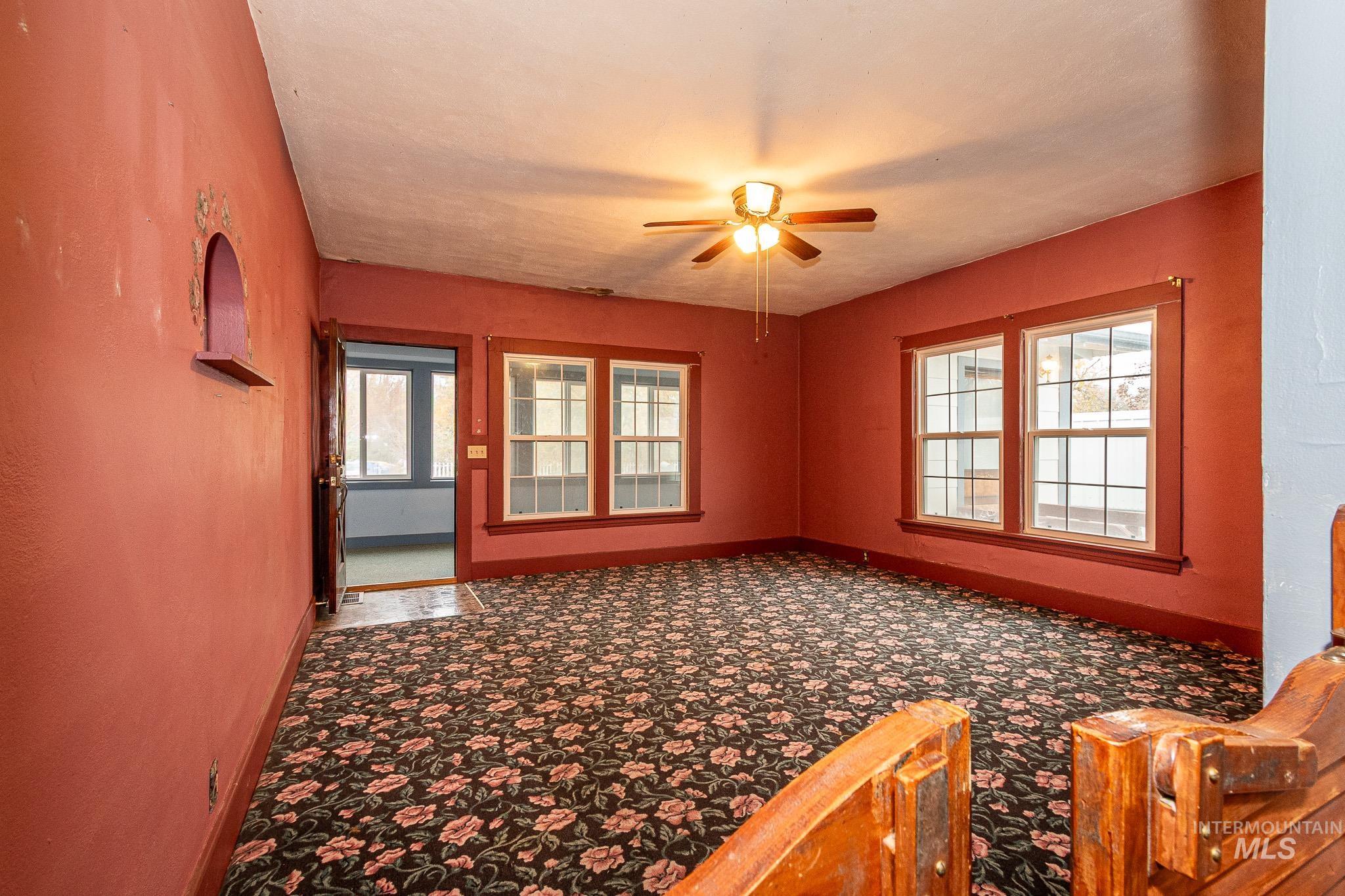 Carpeted empty room with baseboards and ceiling fan
