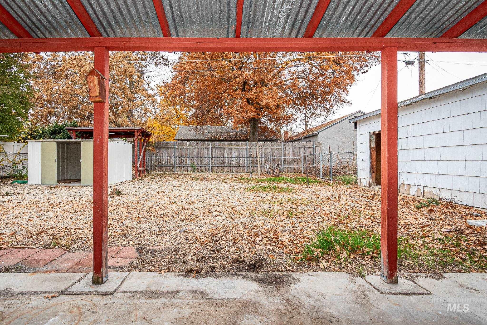 Fenced backyard featuring a shed and a patio