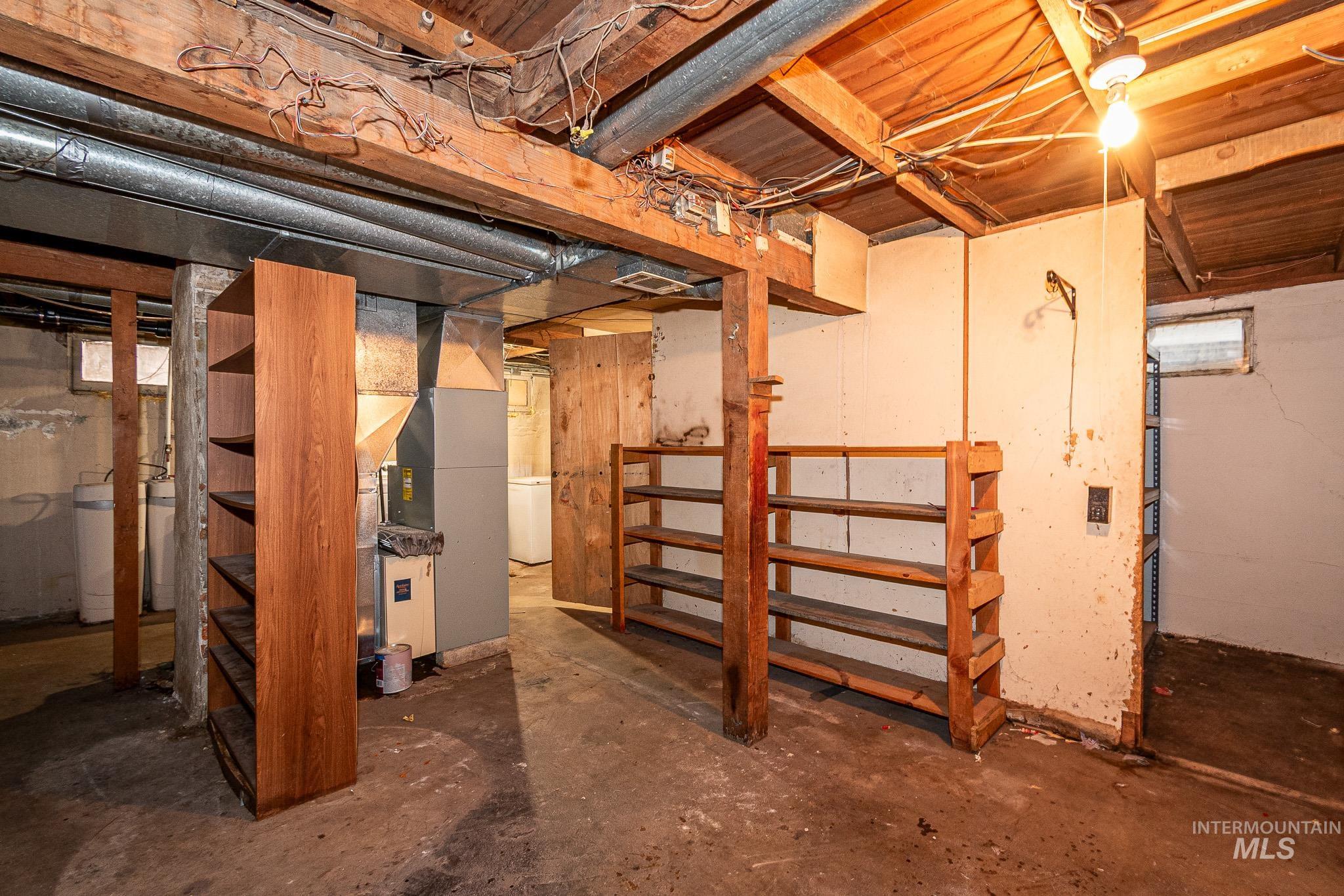 Unfinished below grade area featuring heating unit