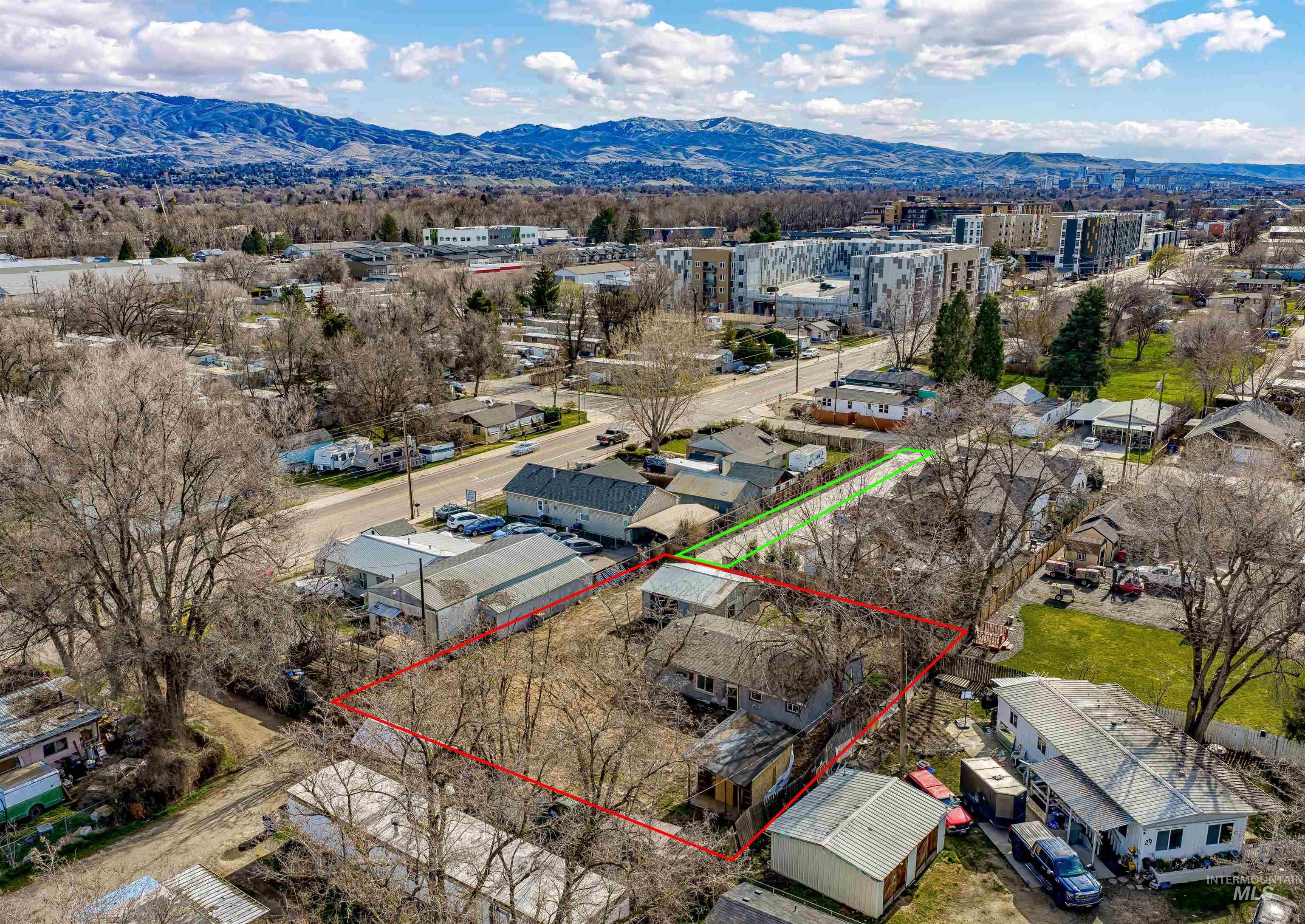 Aerial perspective of suburban area featuring property parcel outlined and mountains