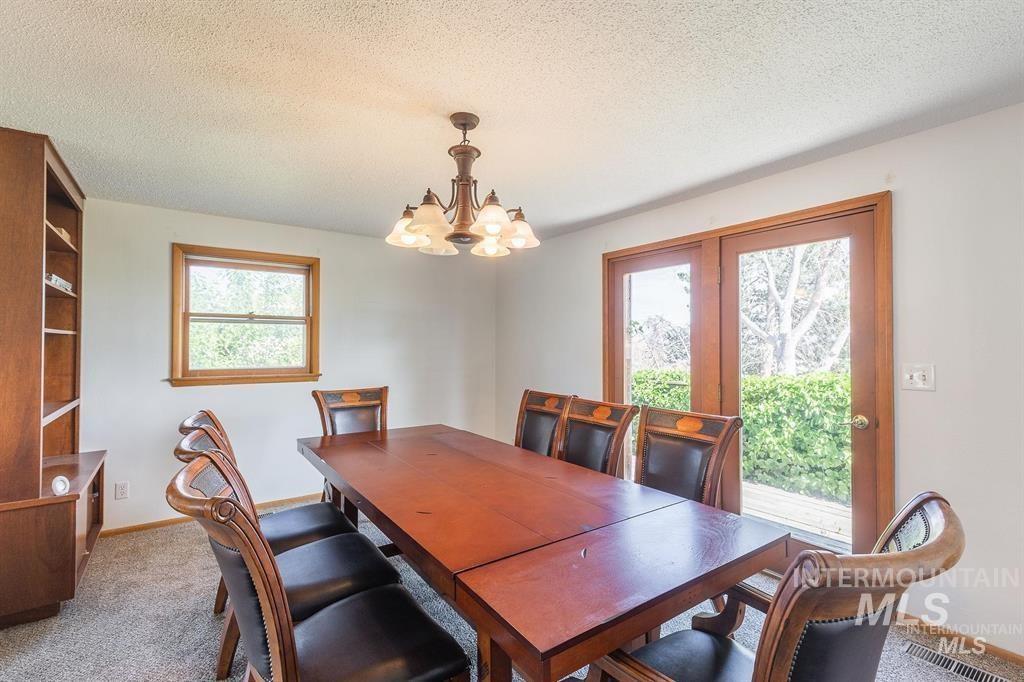 Dining area featuring a chandelier, carpet, and a textured ceiling