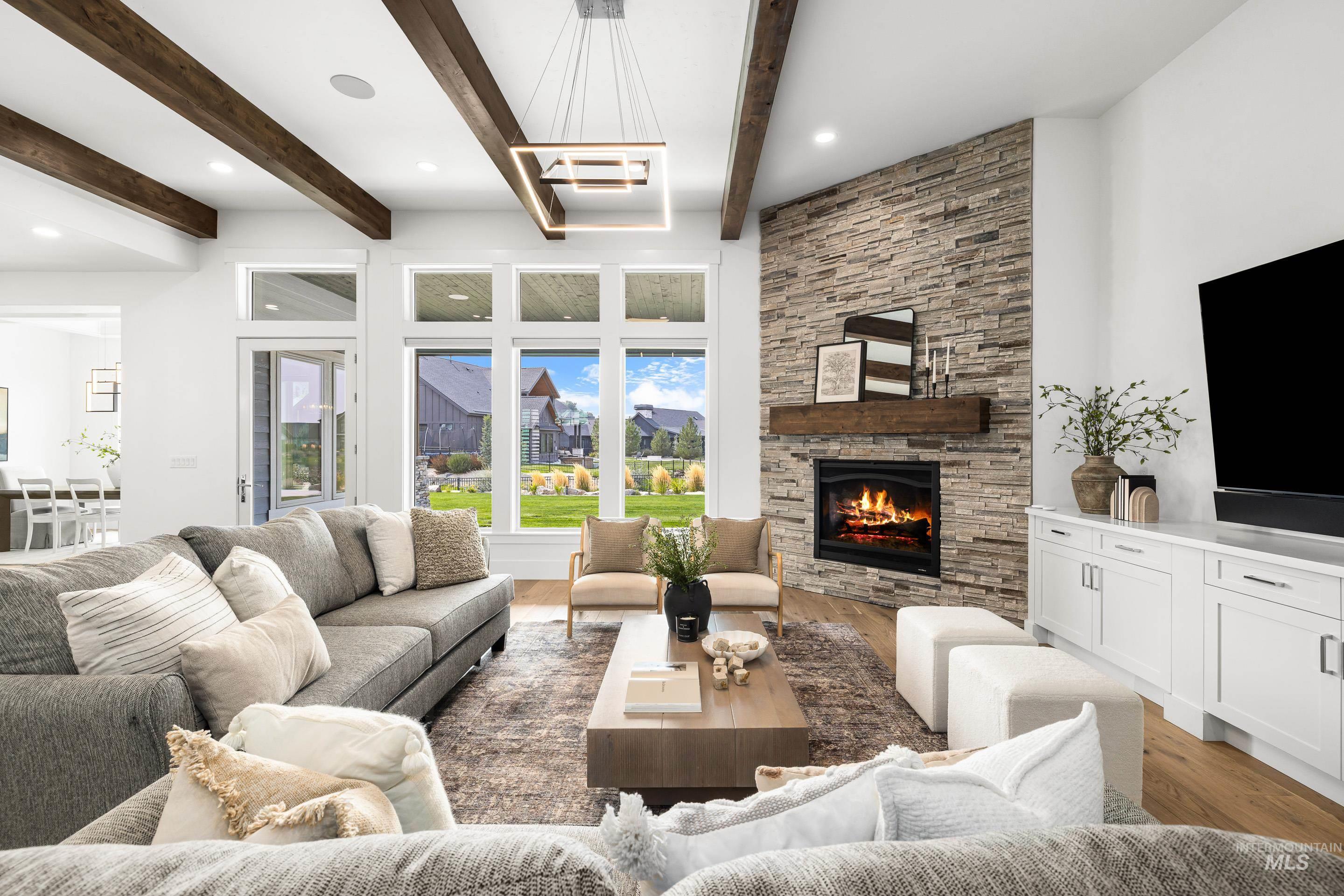 Living area with light wood finished floors, beam ceiling, a fireplace, and recessed lighting