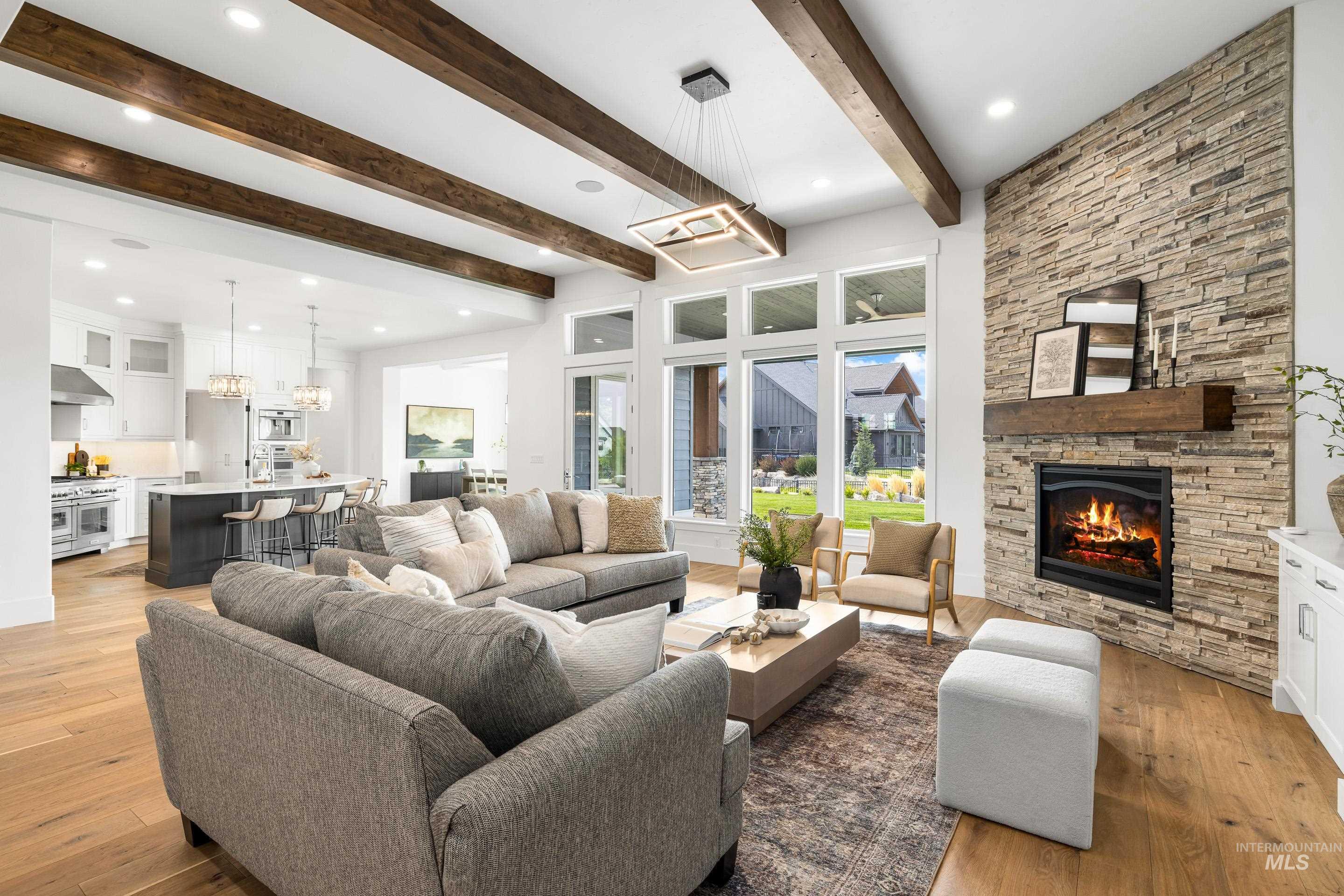 Living room featuring beam ceiling, light wood-style floors, a fireplace, and recessed lighting