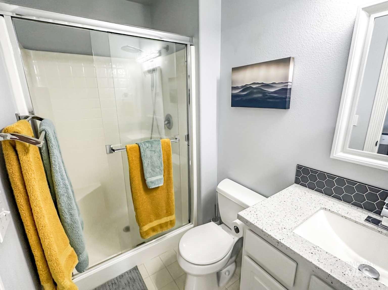 Full bathroom featuring vanity, a shower stall, and light tile patterned flooring