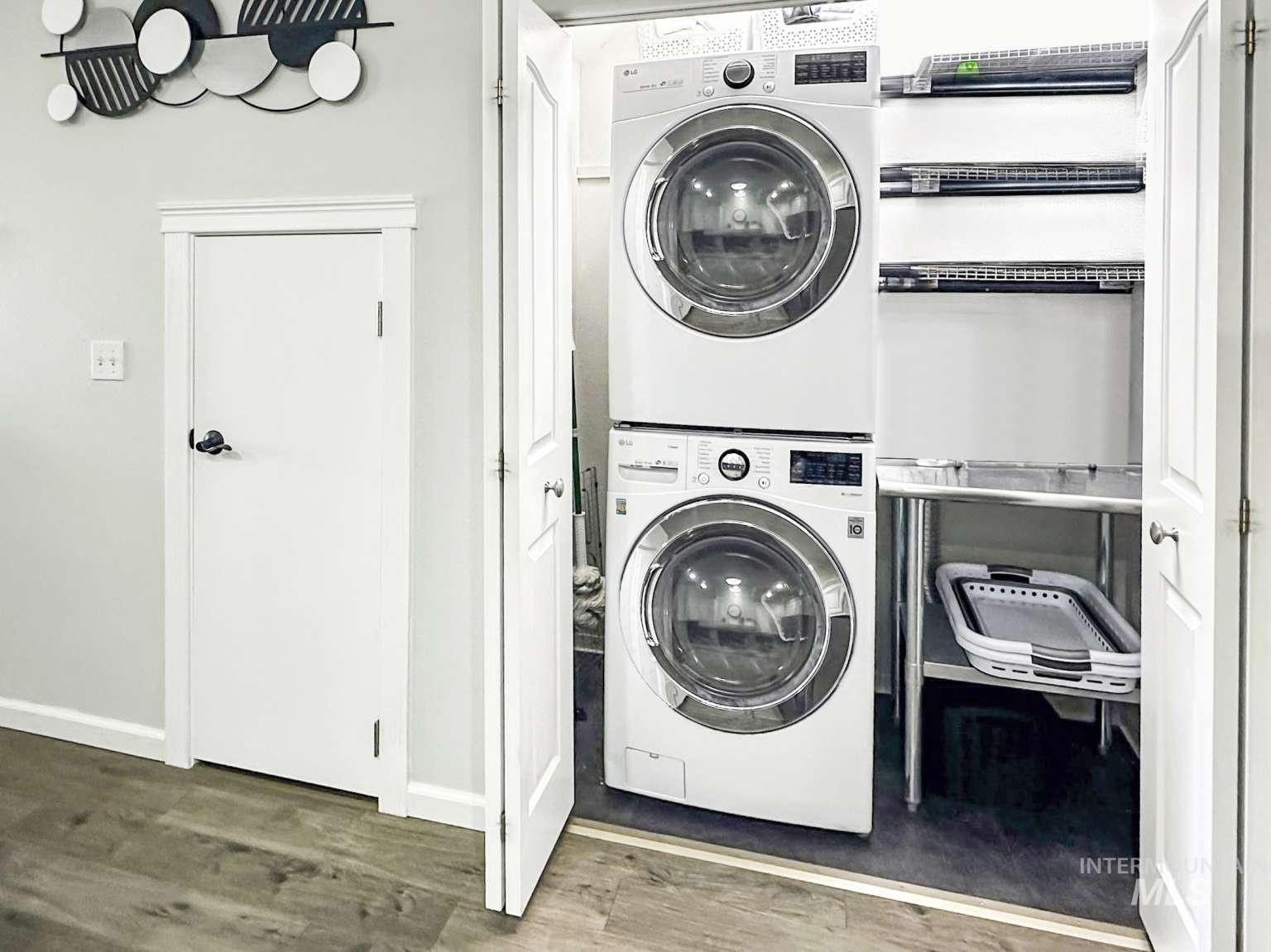Laundry area featuring estacked washer and dryer and wood finished floors