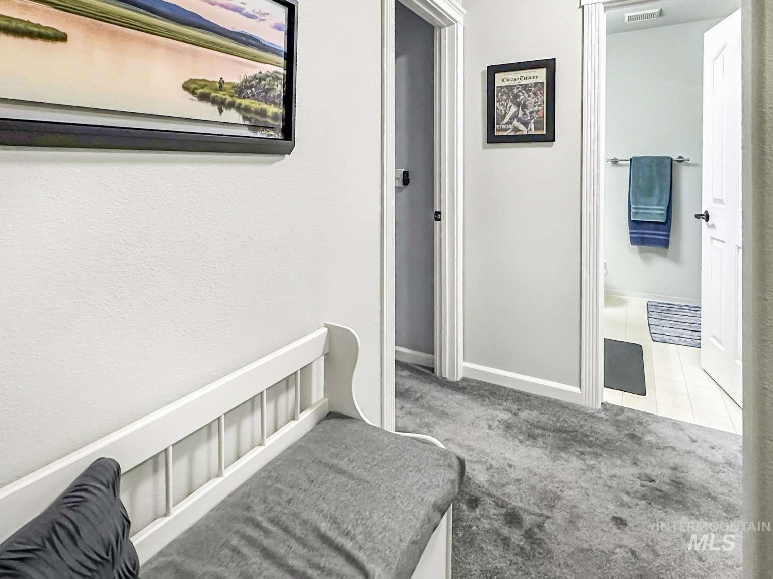 Hall featuring carpet and tile patterned floors