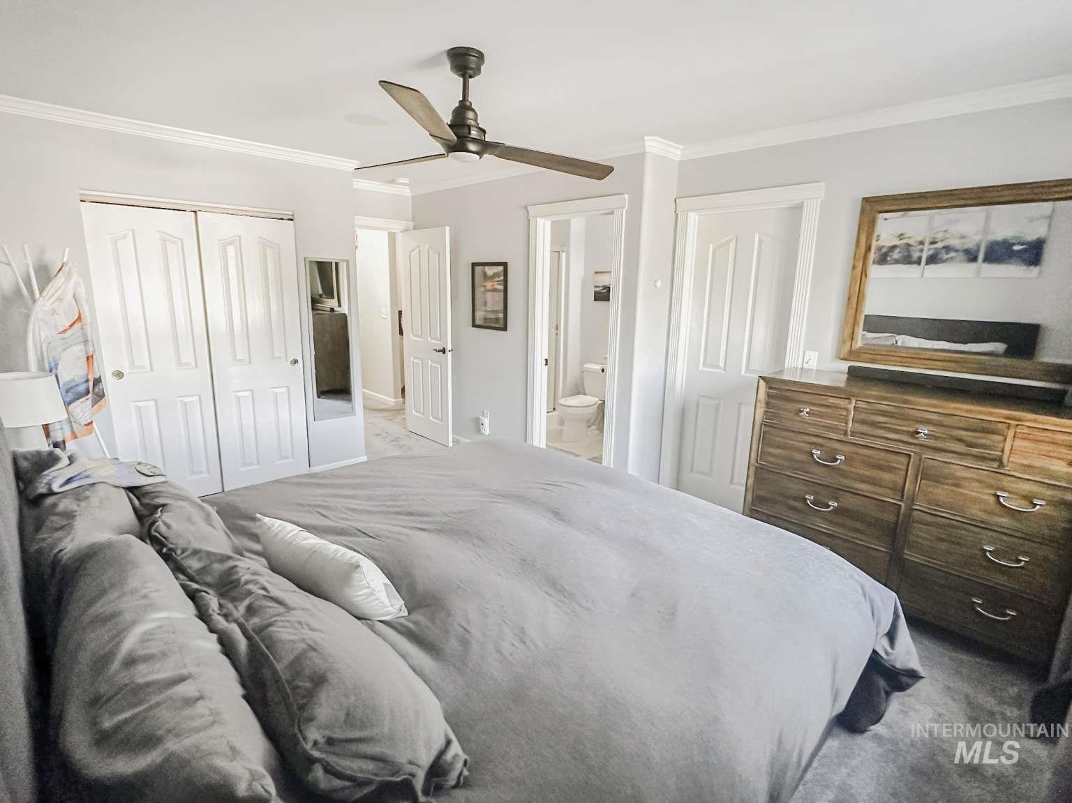 Bedroom featuring ornamental molding, carpet floors, a ceiling fan, a closet, and connected bathroom