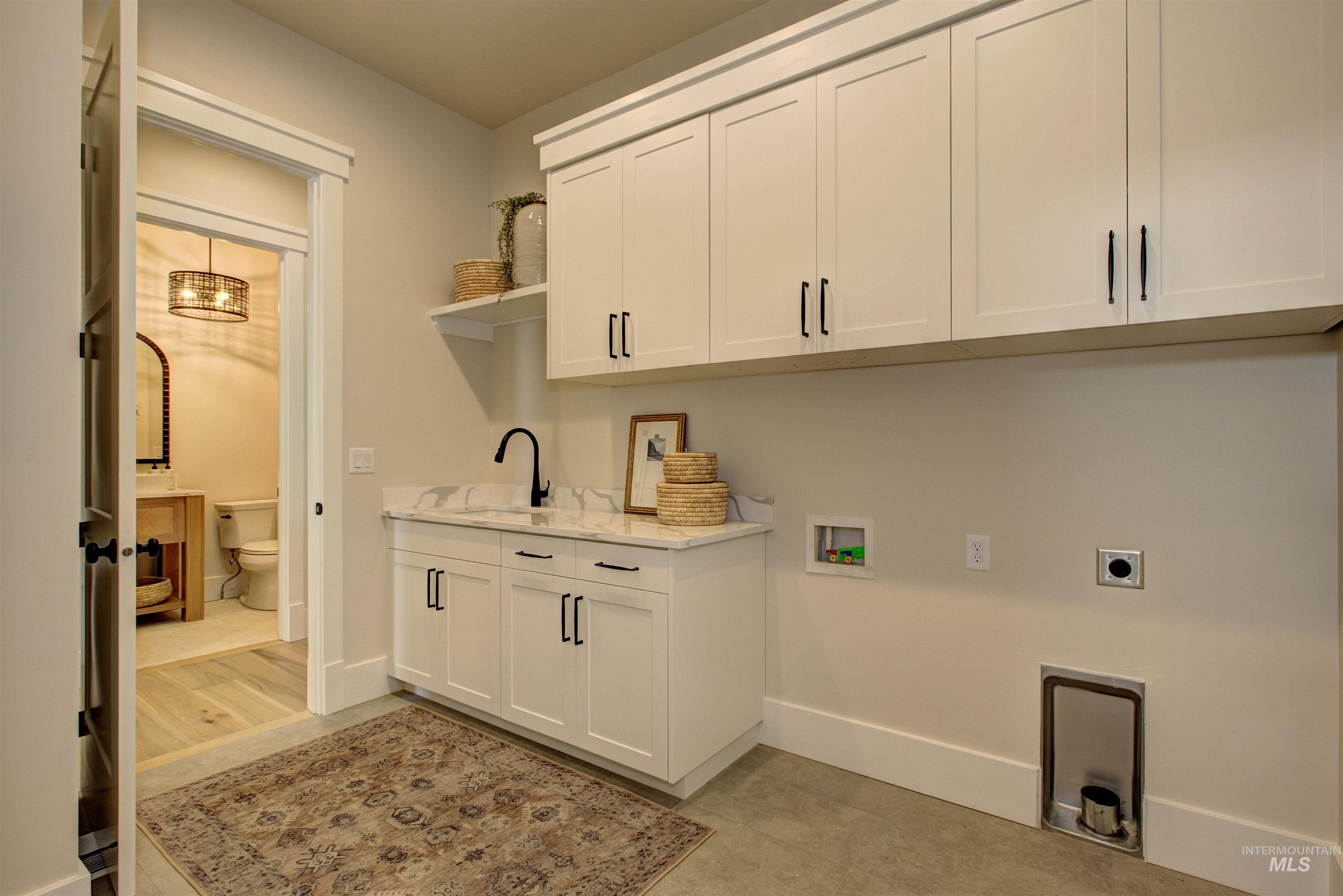Washroom with cabinet space, hookup for an electric dryer, and hookup for a washing machine