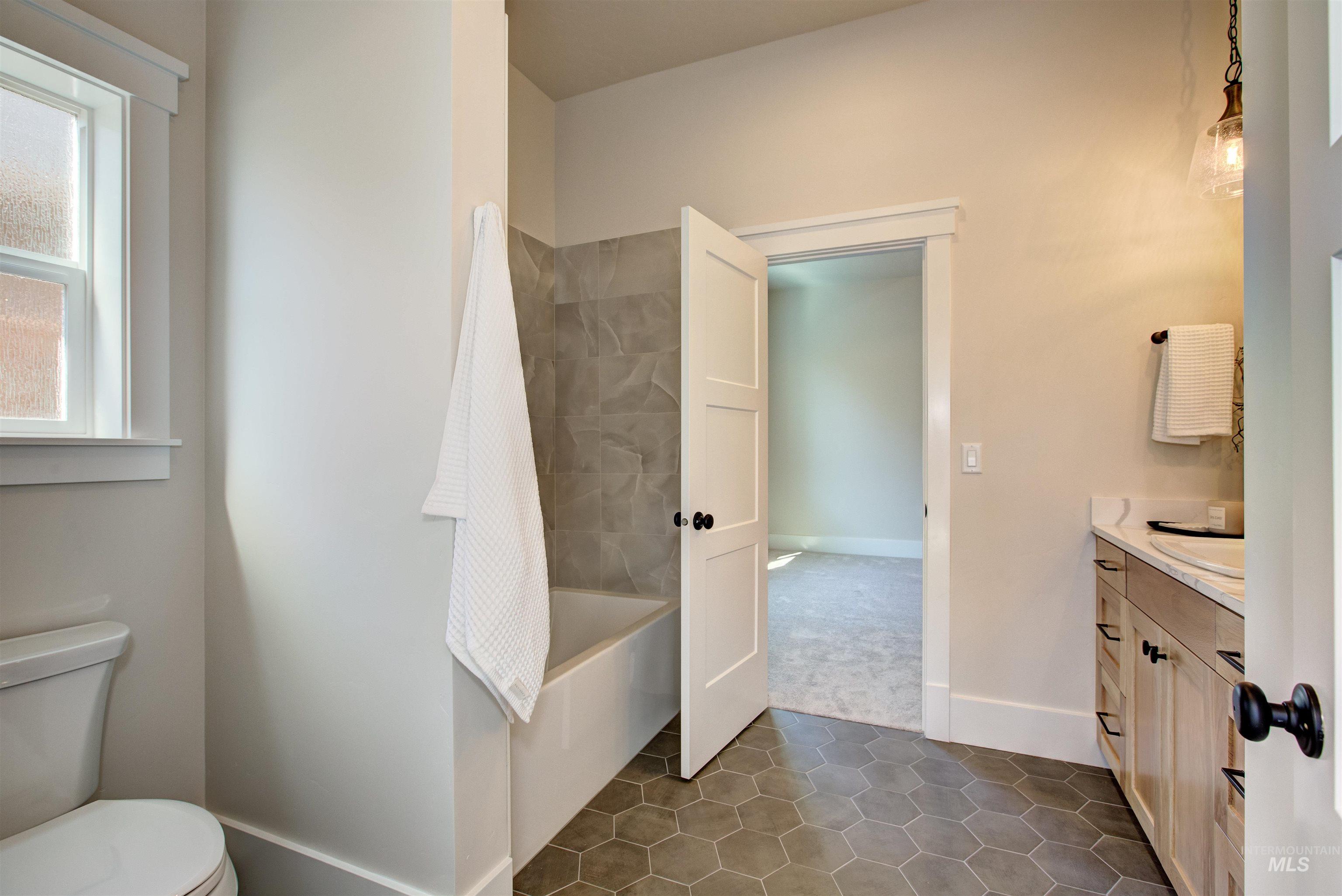 Bathroom with vanity, tile patterned floors, and shower / bathtub combination