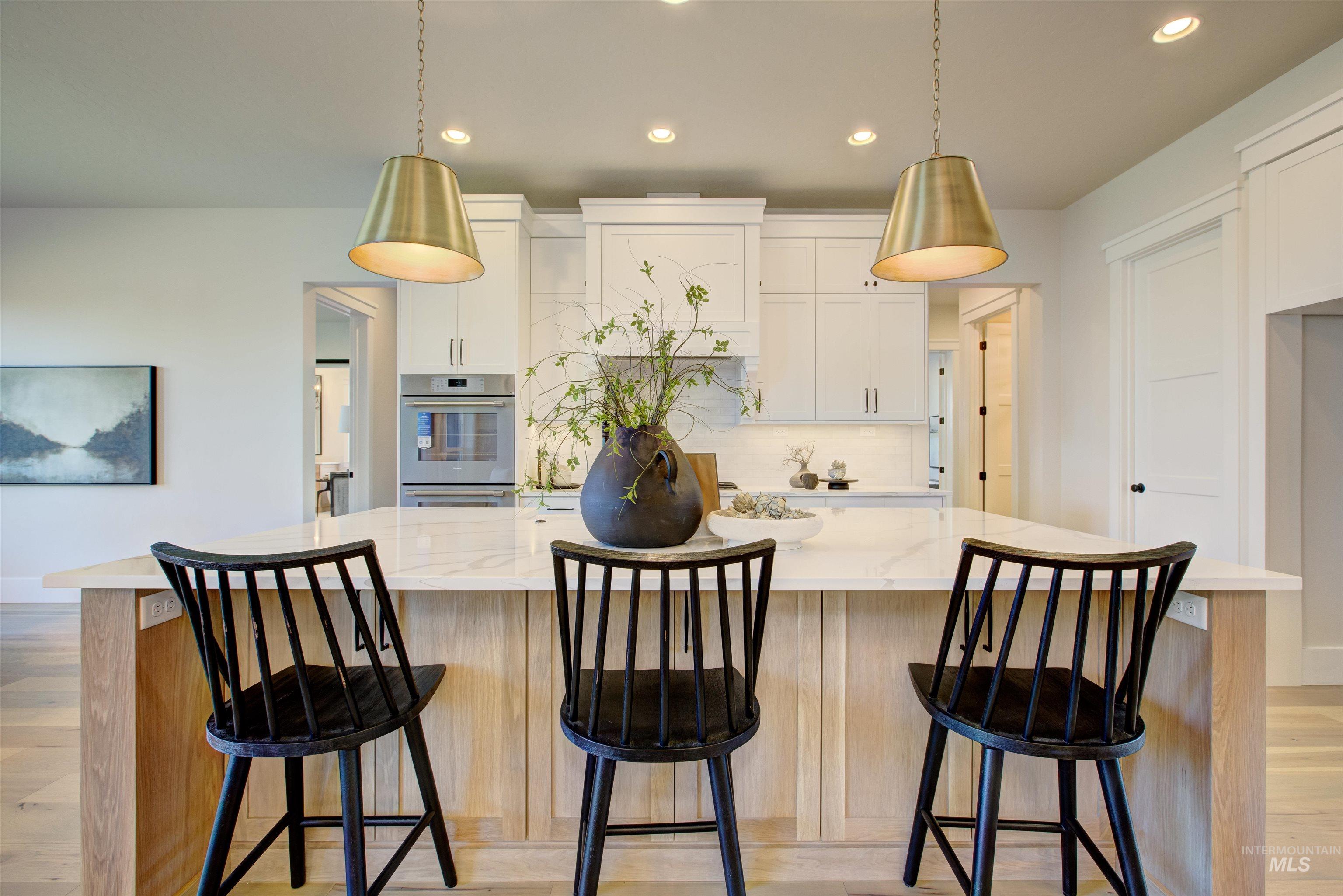 Kitchen with recessed lighting, light wood-style floors, white cabinets, and light stone counters