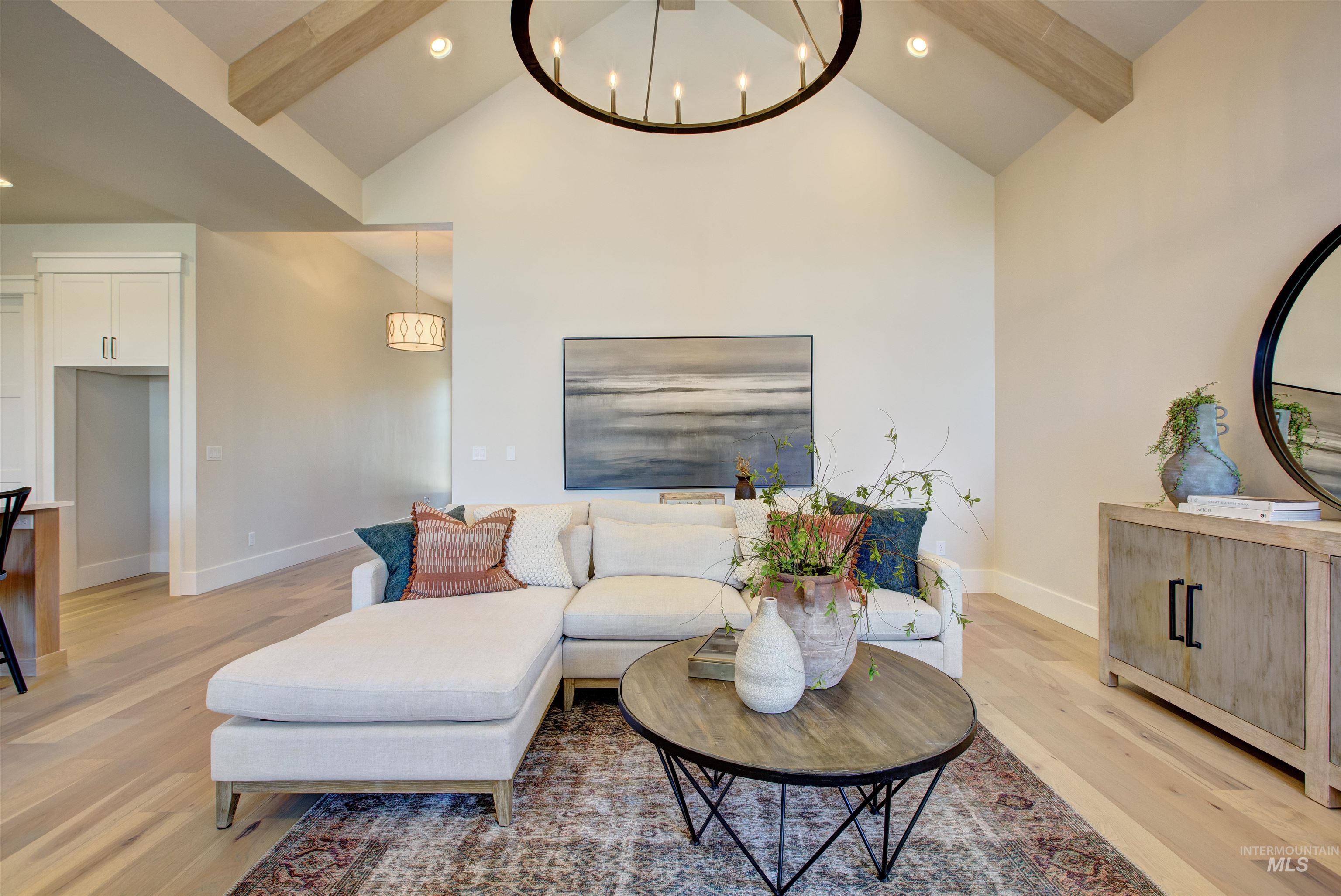 Living area featuring beamed ceiling, high vaulted ceiling, light wood-style flooring, a chandelier, and recessed lighting