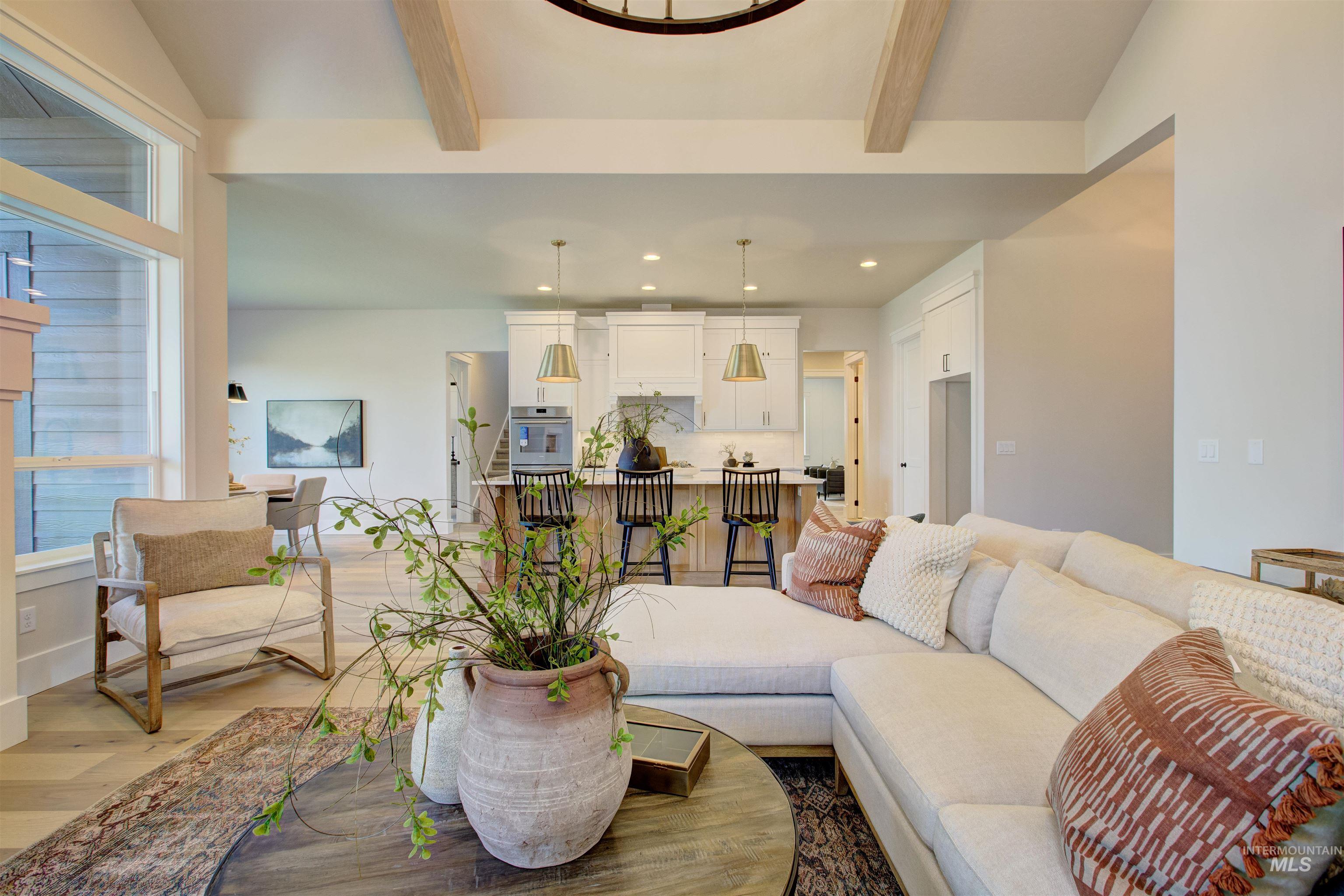 Living room with beamed ceiling, light wood-style floors, and recessed lighting