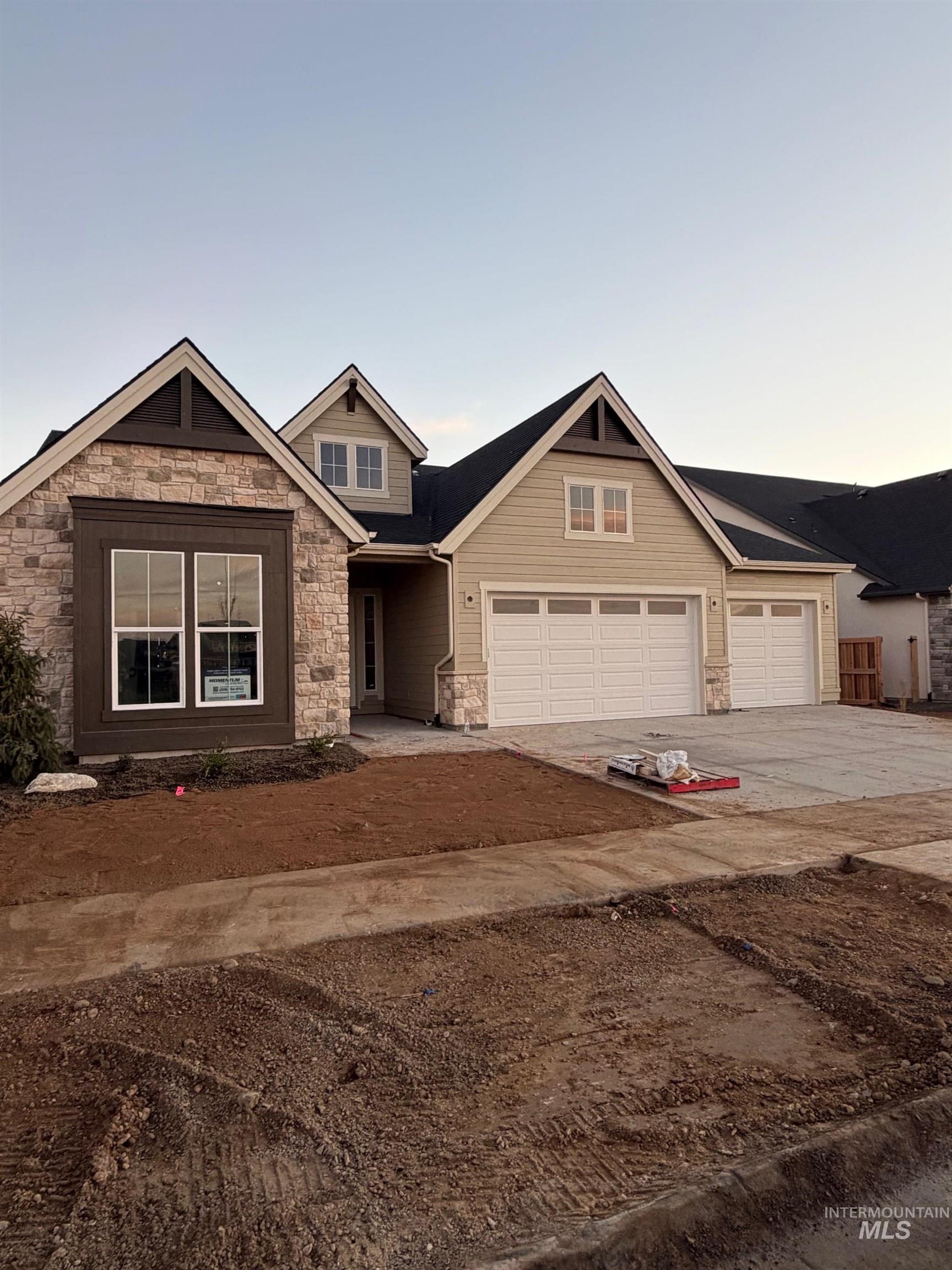 Craftsman house with stone siding and driveway