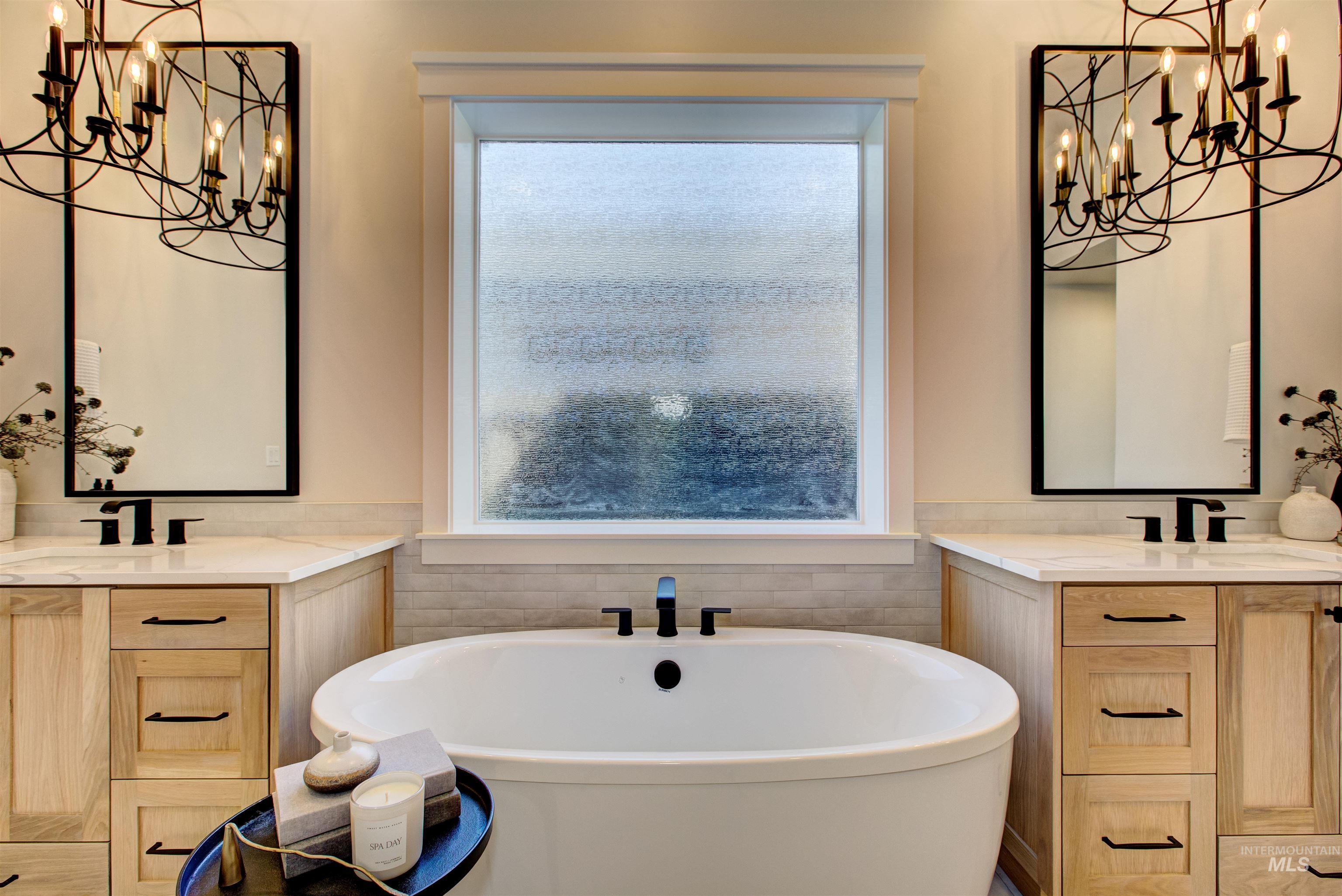 Bathroom with a chandelier, healthy amount of natural light, and a freestanding bath