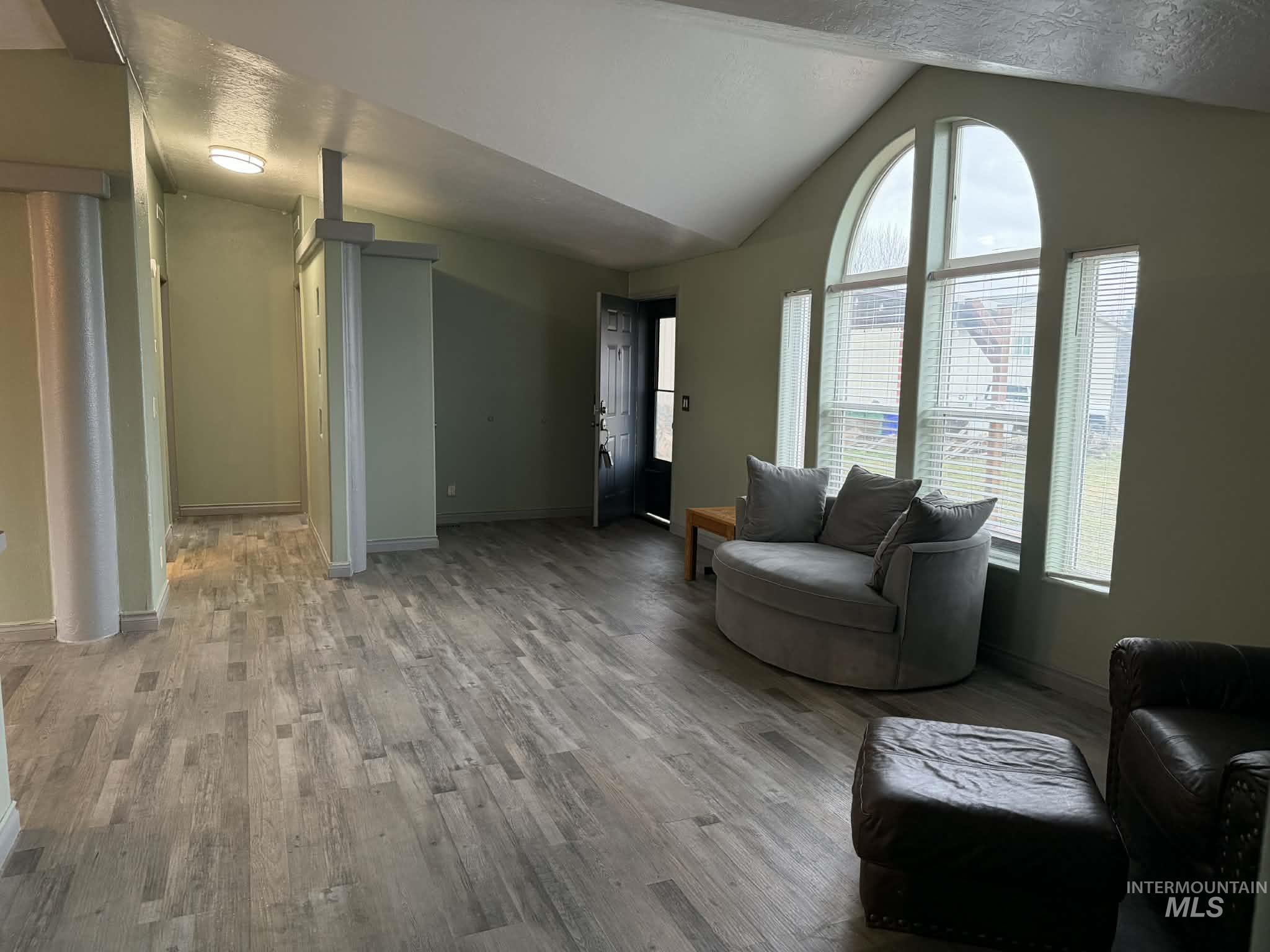 Living area with vaulted ceiling and wood finished floors