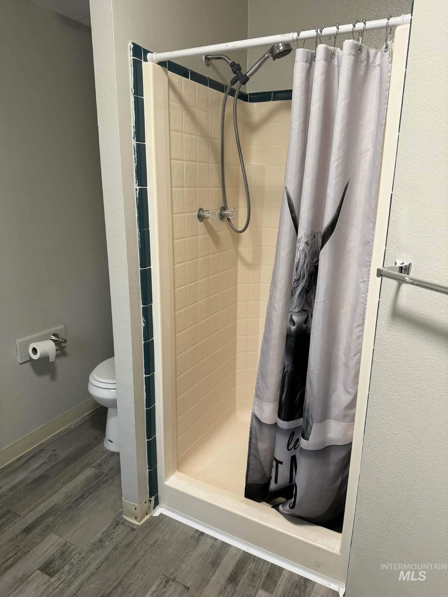 Bathroom featuring a stall shower and wood finished floors