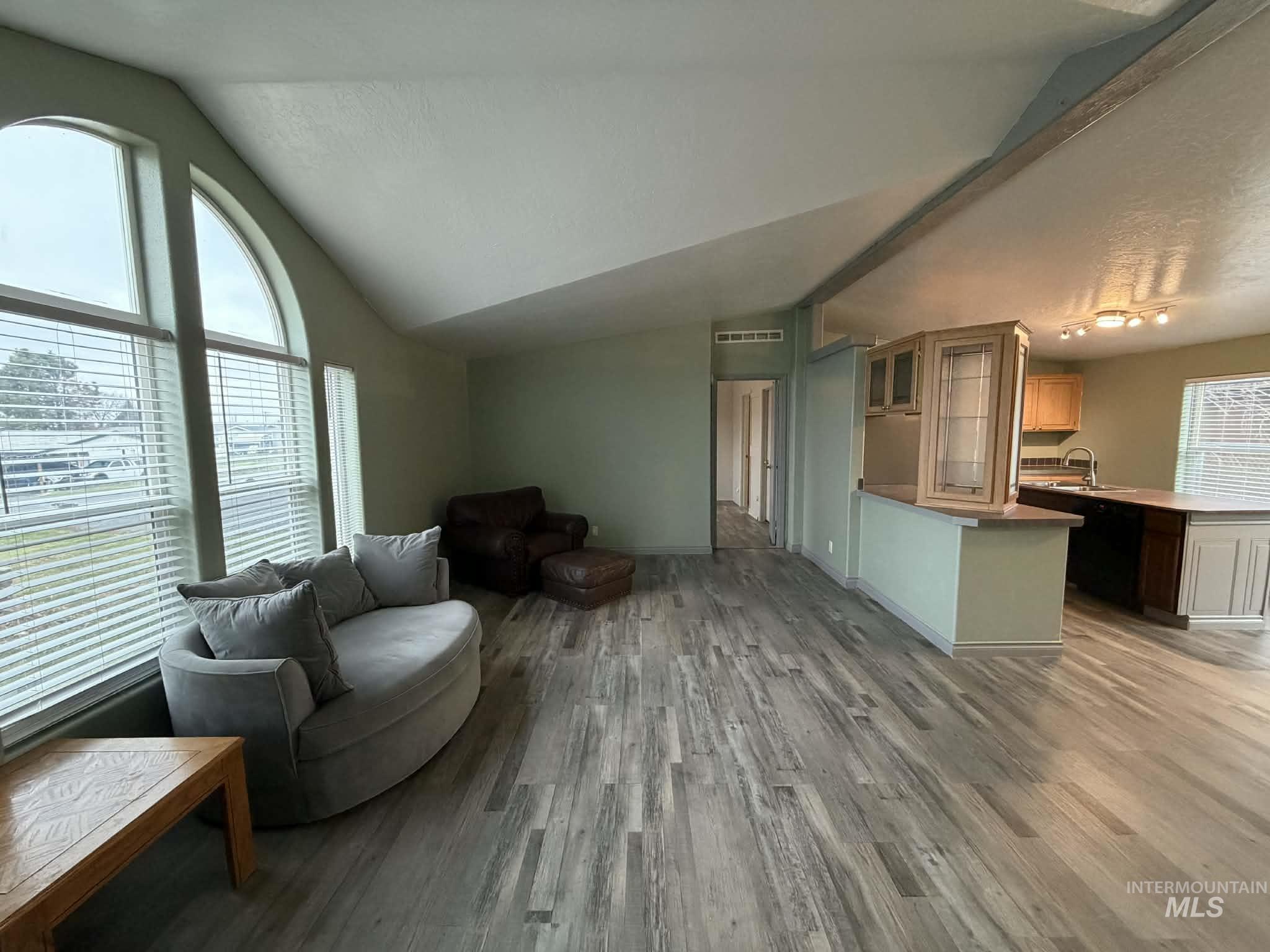 Living room with vaulted ceiling and light wood-style flooring