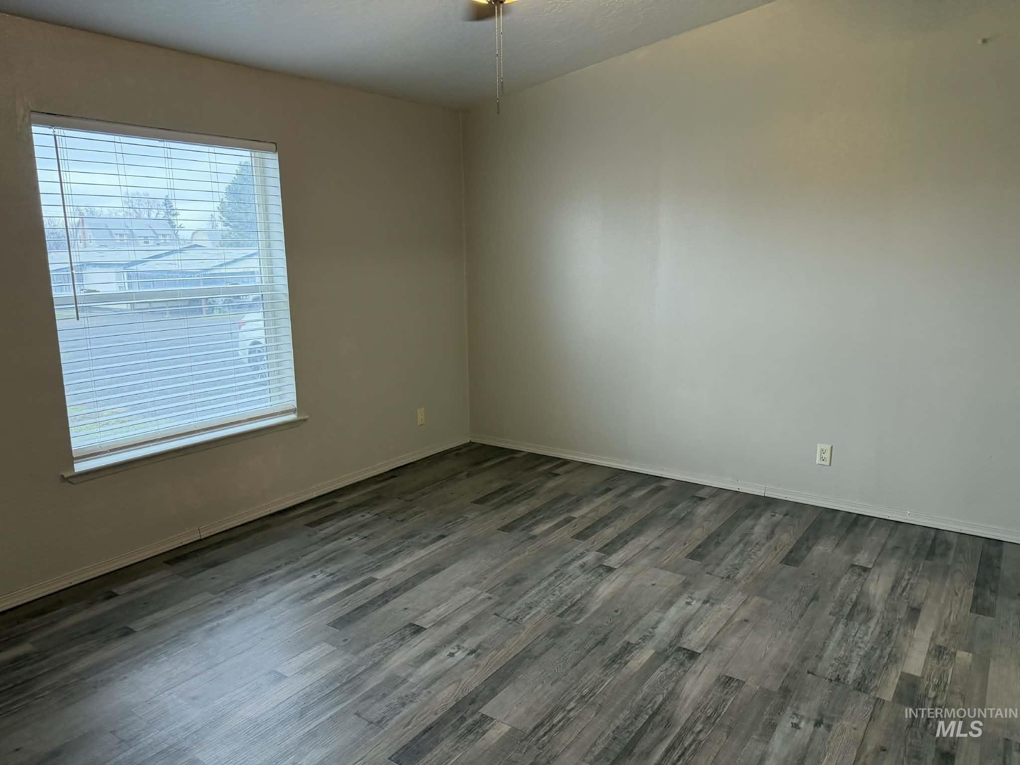 Empty bedroom with dark wood-type flooring and a textured ceiling