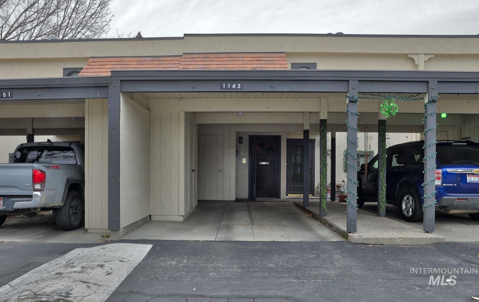 Entrance to property with covered parking and a shingled roof