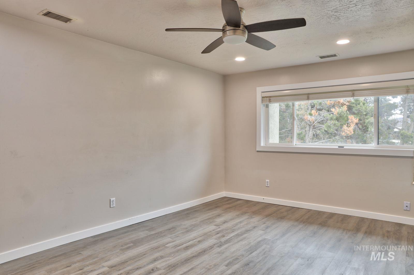 Empty room with a ceiling fan, light wood finished floors, recessed lighting, and a textured ceiling