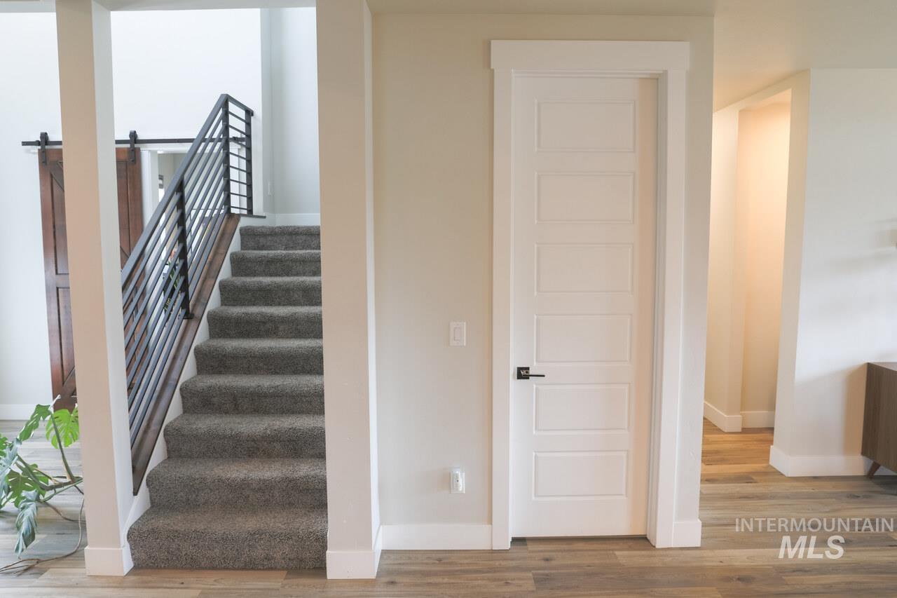 Stairs featuring a barn door and wood finished floors