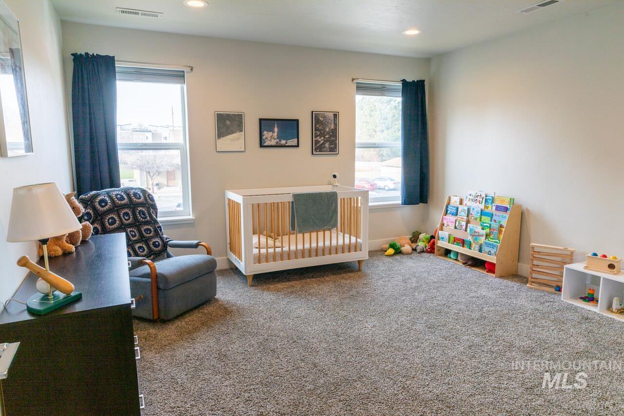 Bedroom with a crib, carpet flooring, and recessed lighting