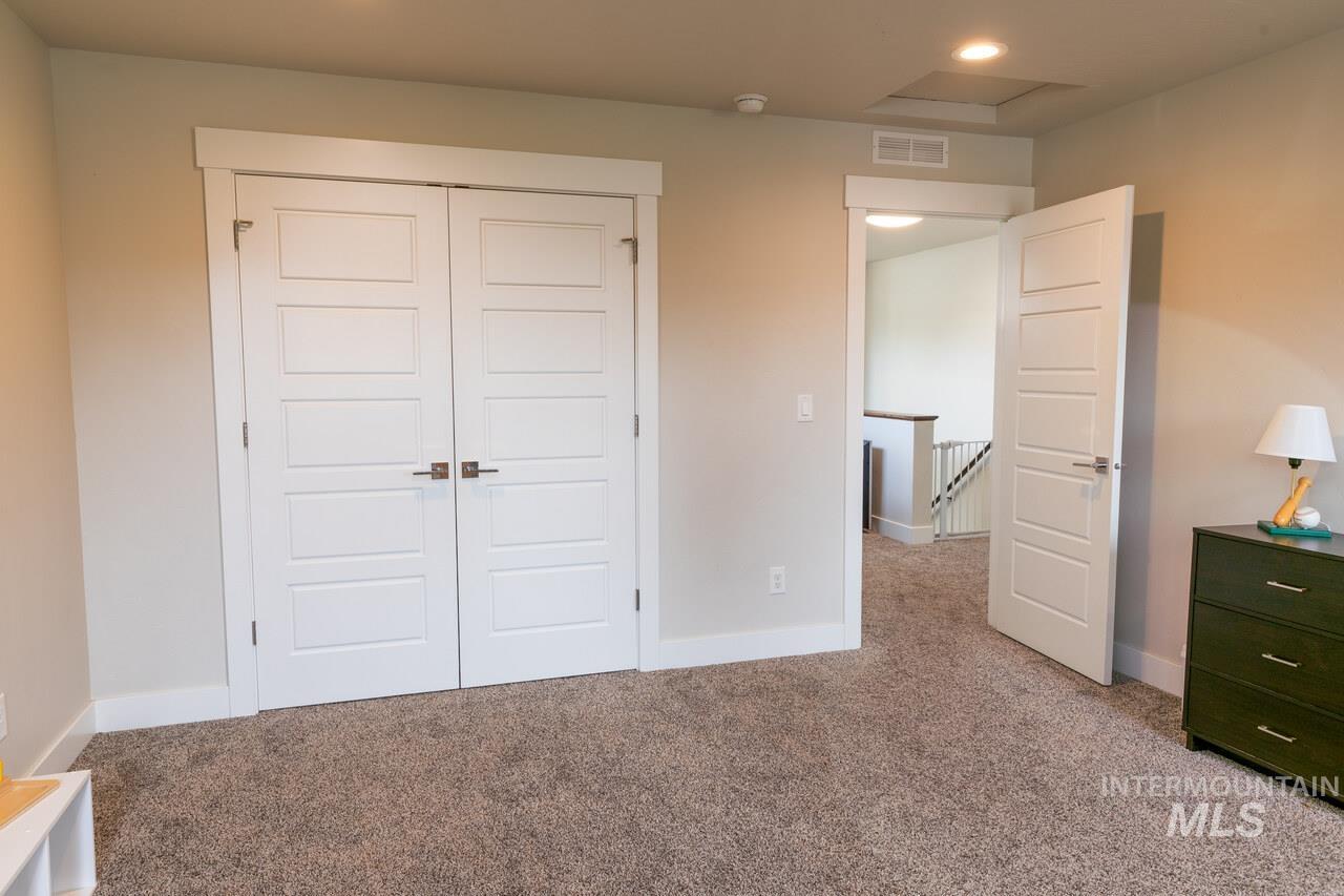 Unfurnished bedroom featuring a closet and light carpet