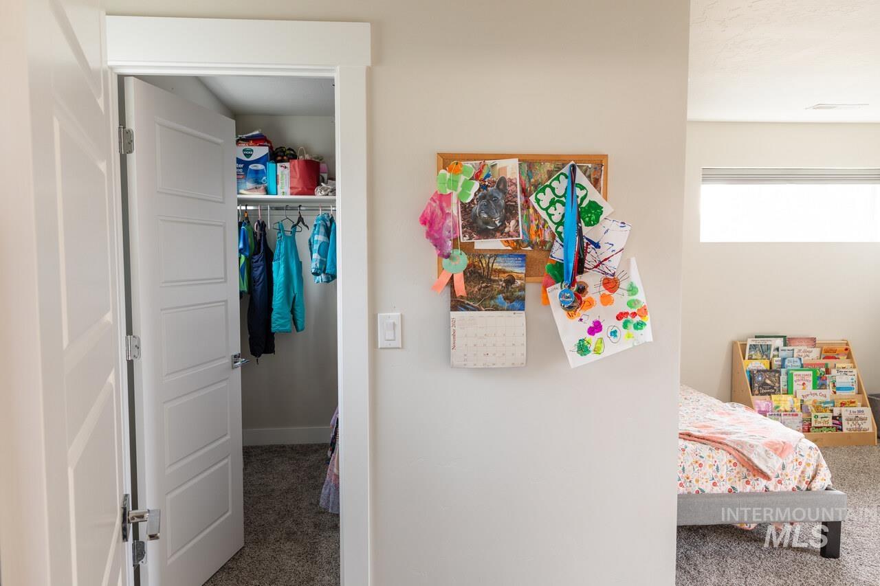 Carpeted bedroom with a walk in closet