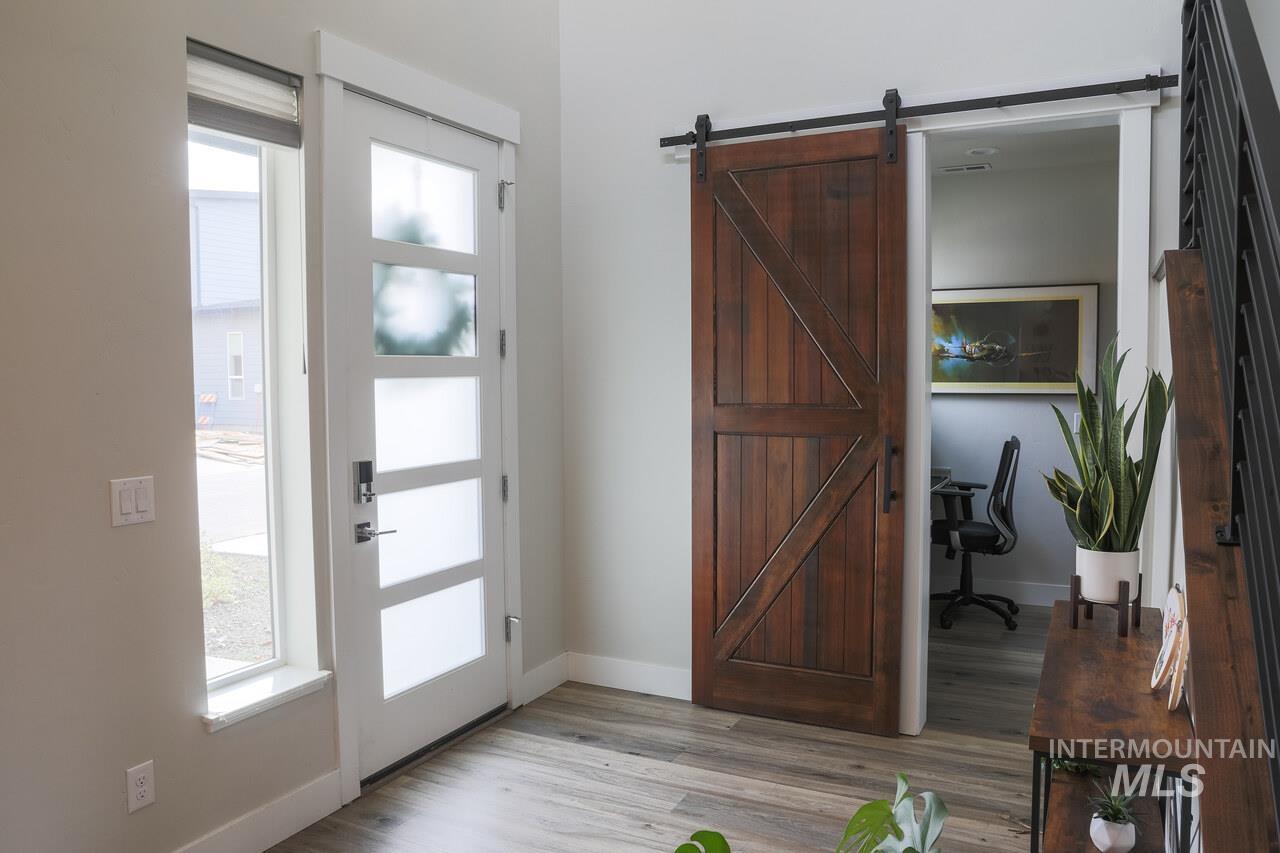 Foyer entrance with light wood finished floors and a barn door