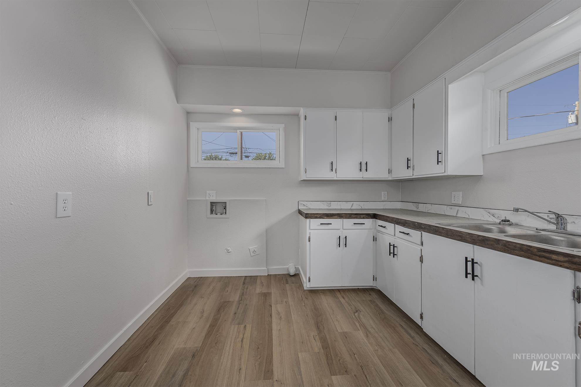 Washroom featuring cabinet space, light wood finished floors, and hookup for a washing machine