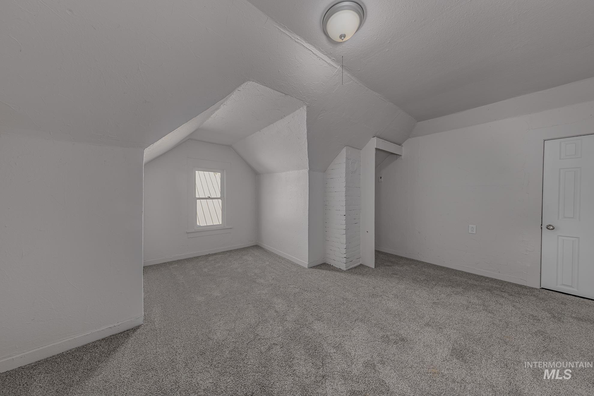 Bonus room with carpet floors and vaulted ceiling