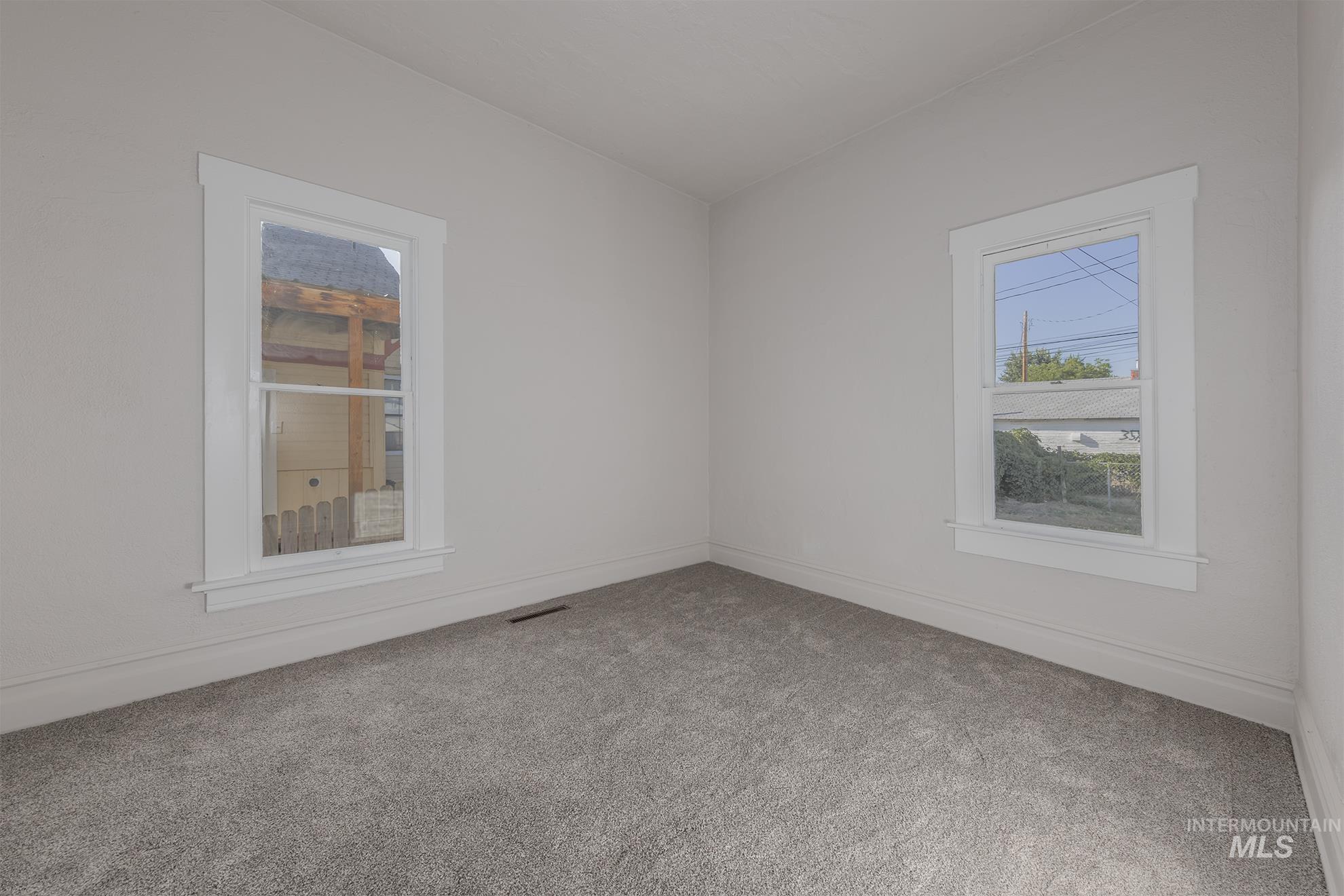 Carpeted spare room with baseboards