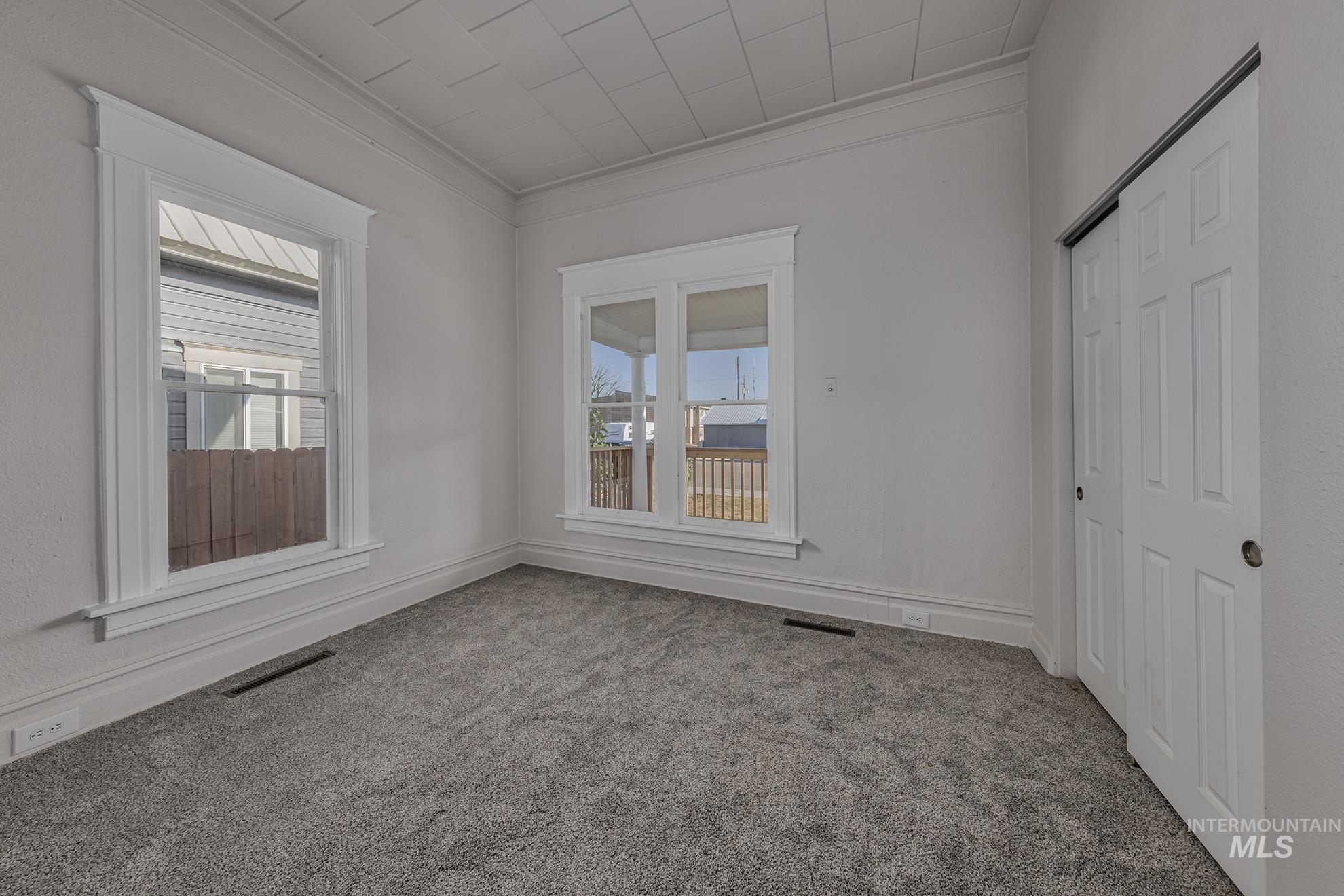 Spare room featuring crown molding and carpet floors
