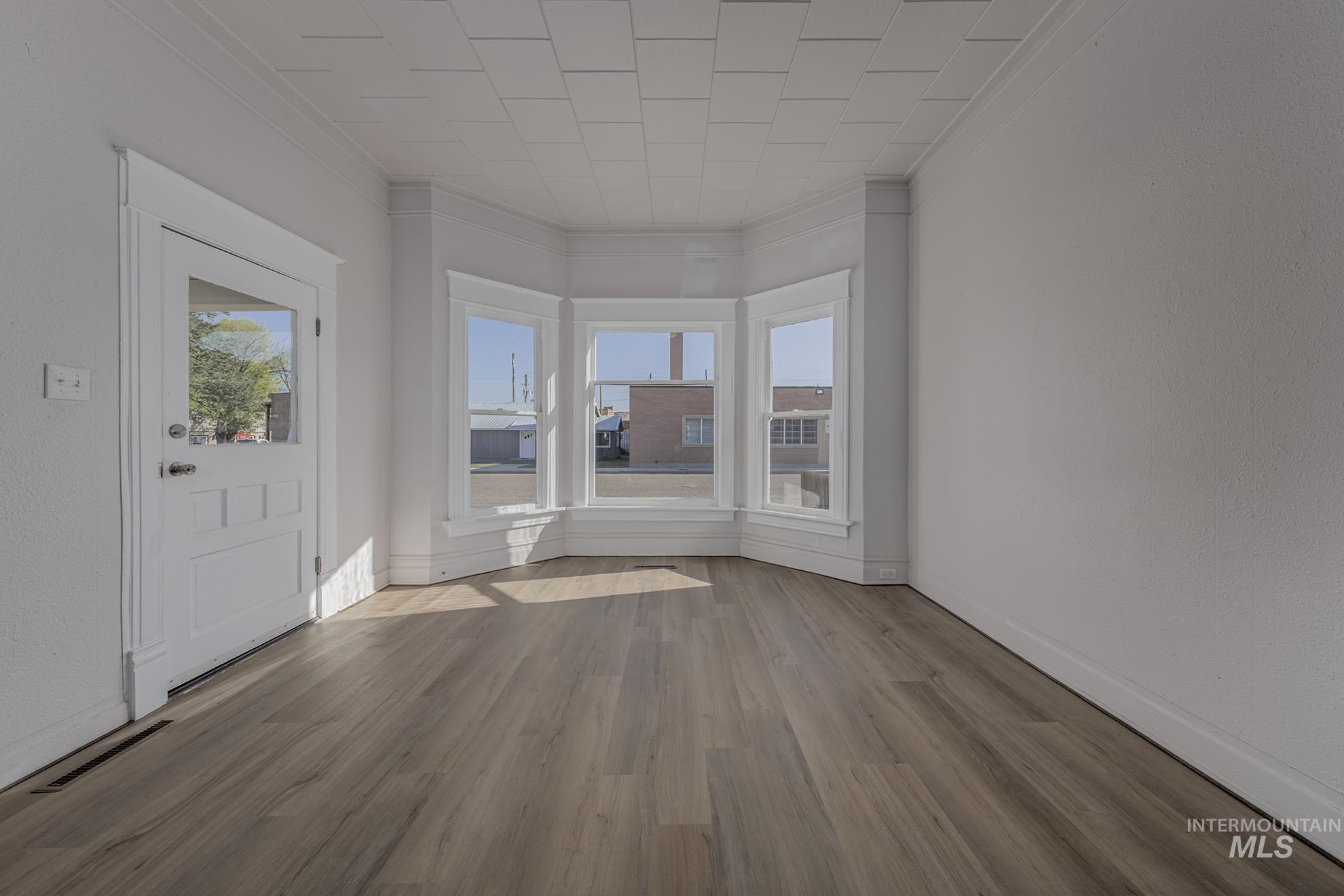 Entryway with crown molding and wood finished floors