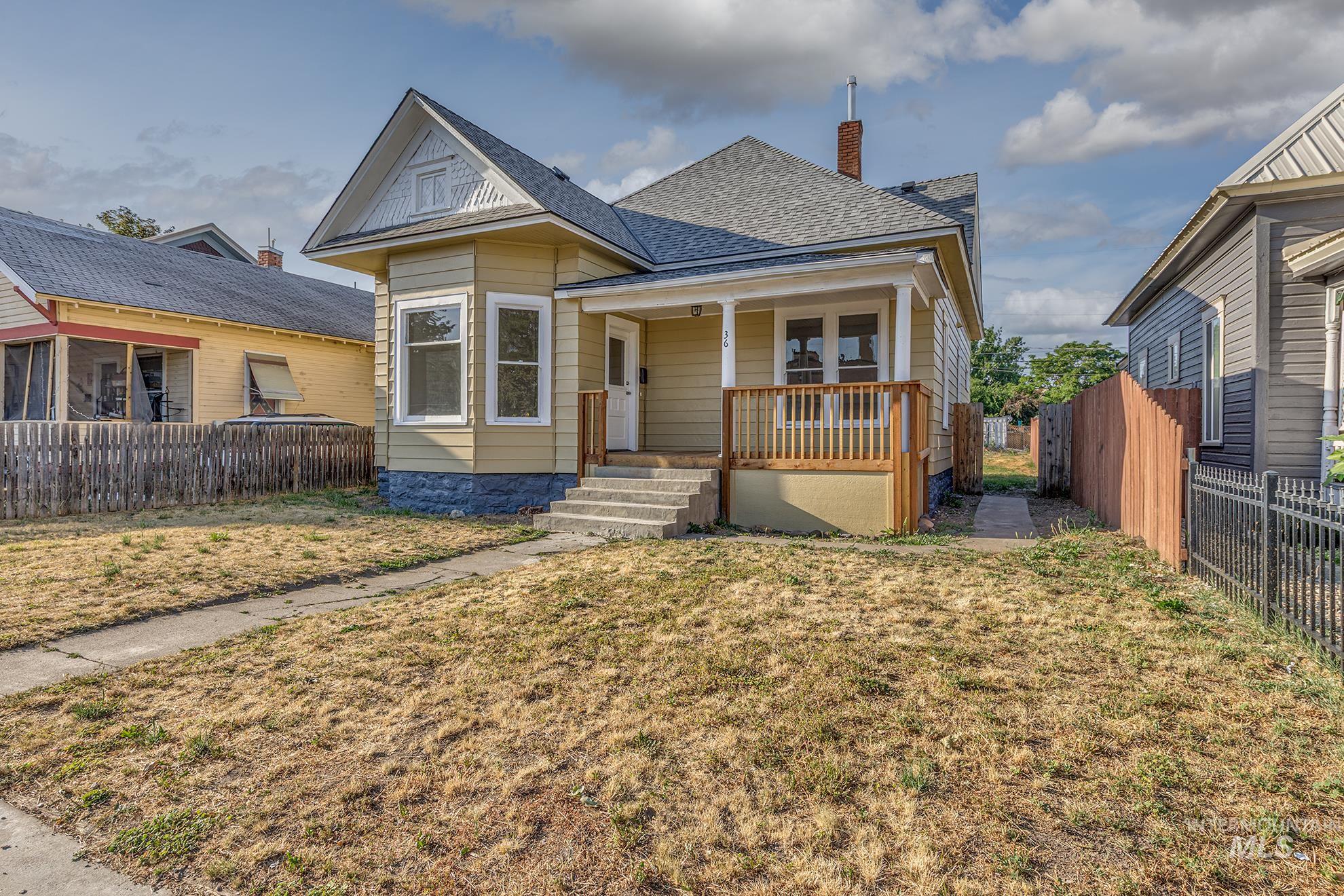 View of front of property featuring a porch, roof with shingles, a fenced backyard