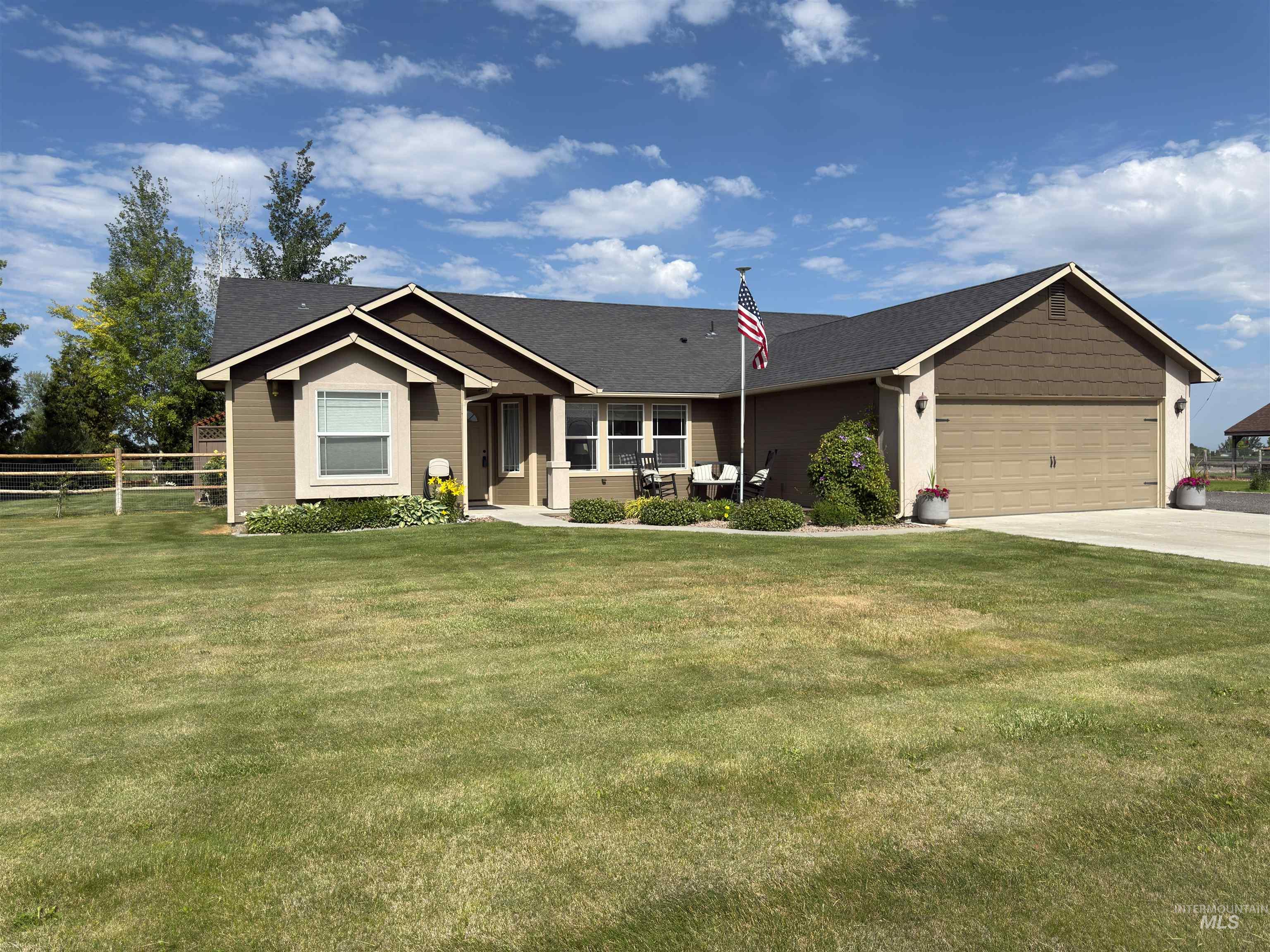 Single story home featuring driveway, an attached garage, and roof with shingles