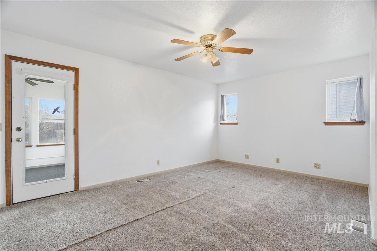 Unfurnished room featuring ceiling fan, plenty of natural light, and carpet