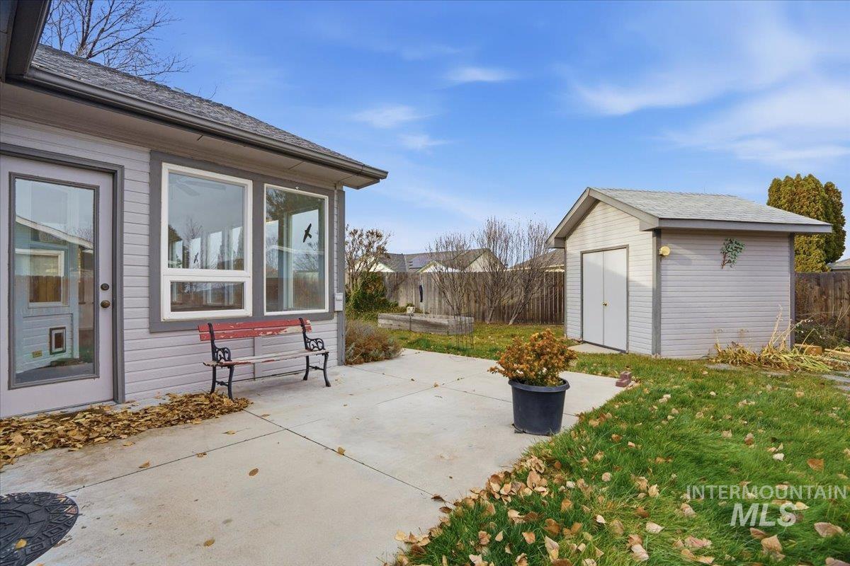 Fenced backyard with a patio and a storage shed