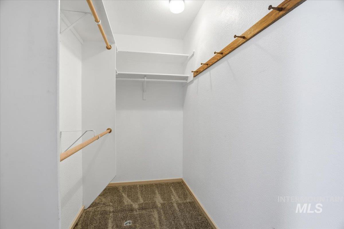 Walk in closet with dark carpet