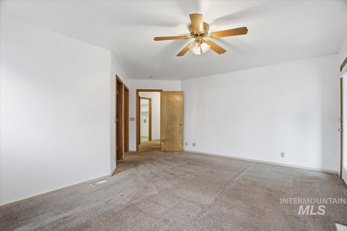 Spare room with ceiling fan and carpet floors