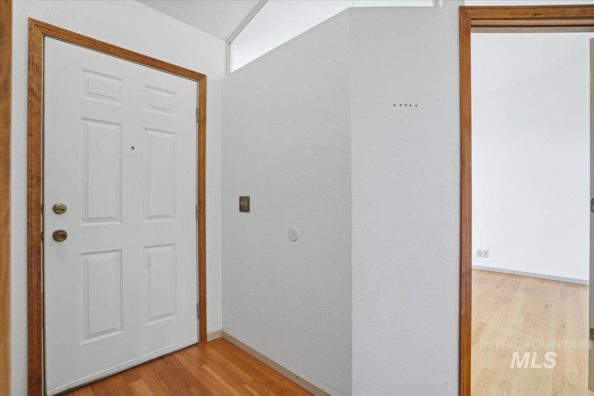 Foyer entrance with light wood-style flooring and baseboards