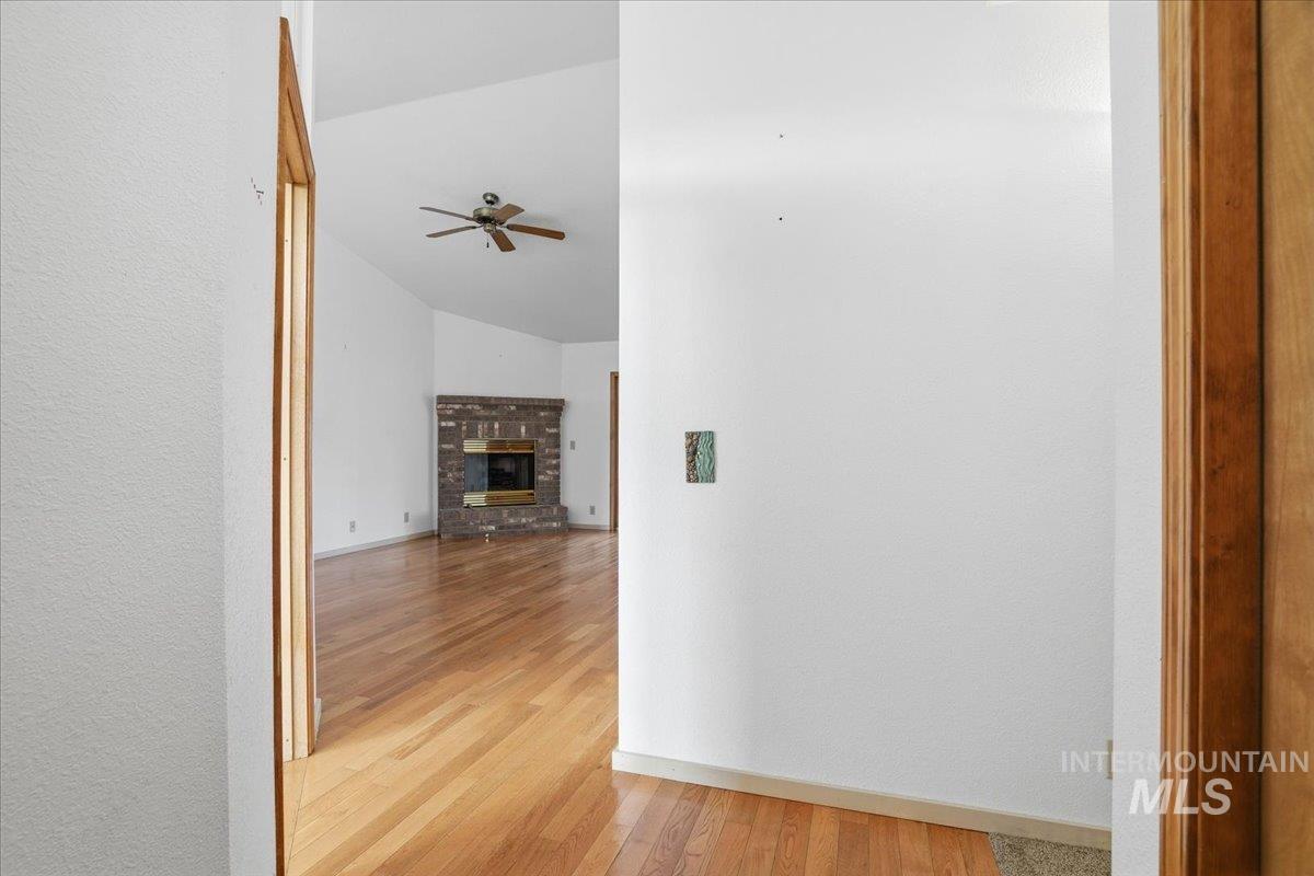 Hallway featuring vaulted ceiling and light wood finished floors