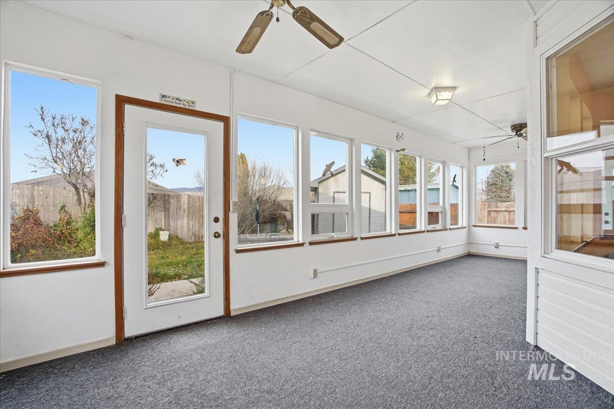 Unfurnished sunroom with carpet and baseboards