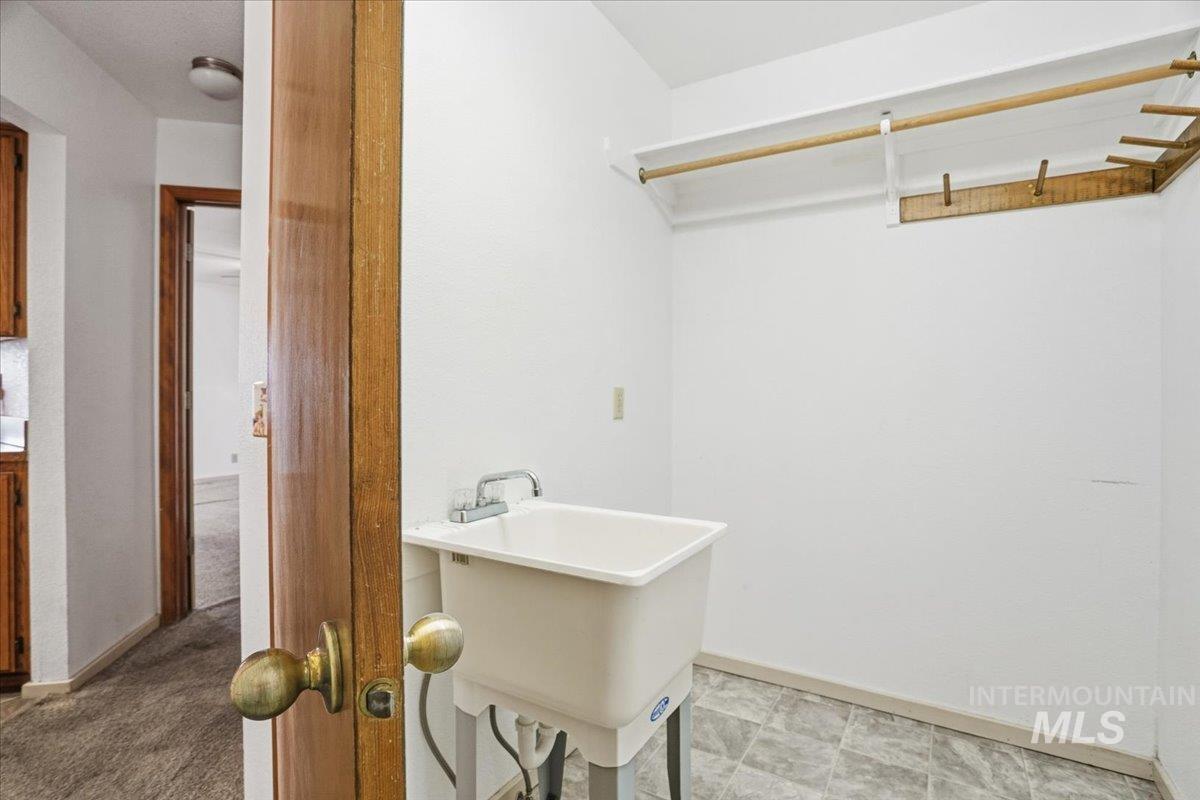 Laundry room featuring baseboards and a sink