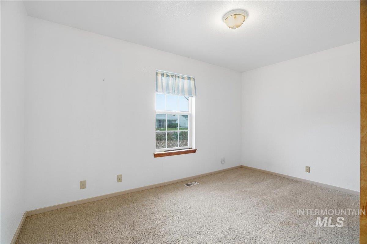 Unfurnished room featuring light colored carpet and baseboards